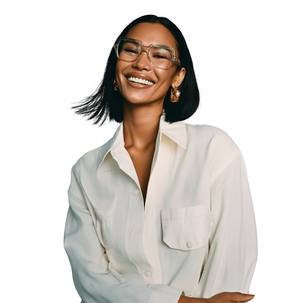 Smiling person with medium-length dark hair, wearing a white shirt, against a solid background.