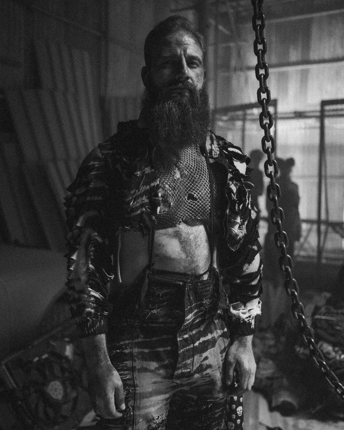 Bearded performer in costume on an industrial music video set