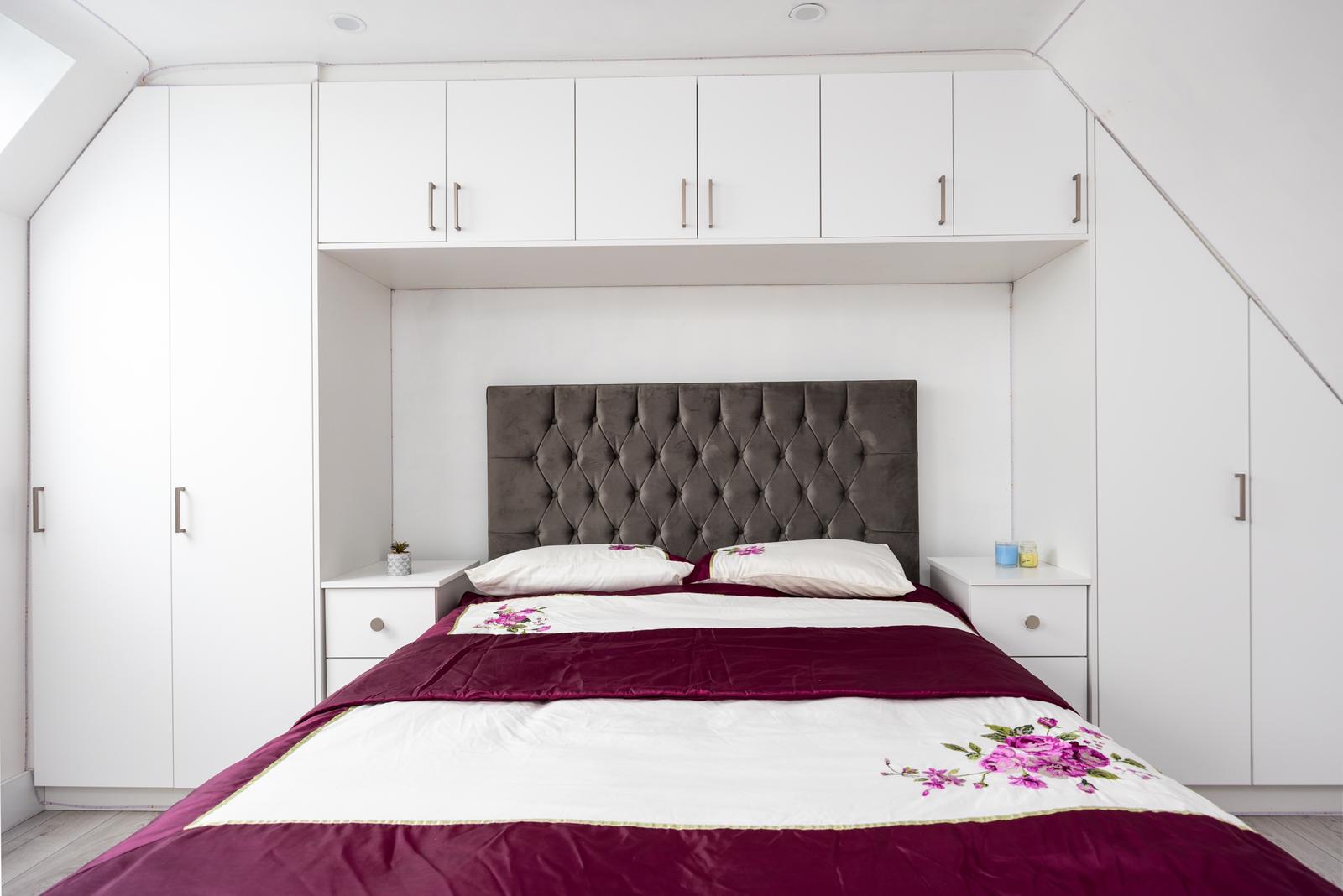 Modern bathroom featuring a walk-in shower, wooden vanity, round mirror, and elegant marble tiles.