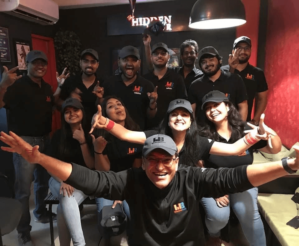 A large team gathering posing for pictures after an exciting competitive game of mystery escape room