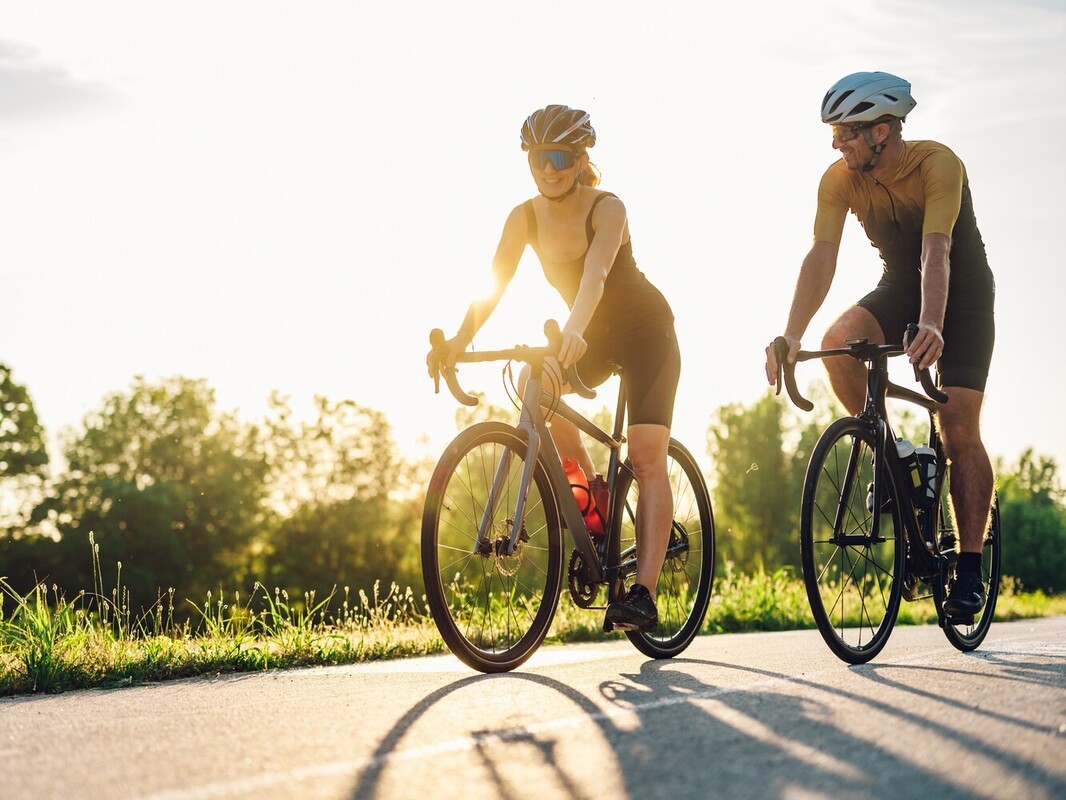 couple bike riding for weight loss together outside to stay fit