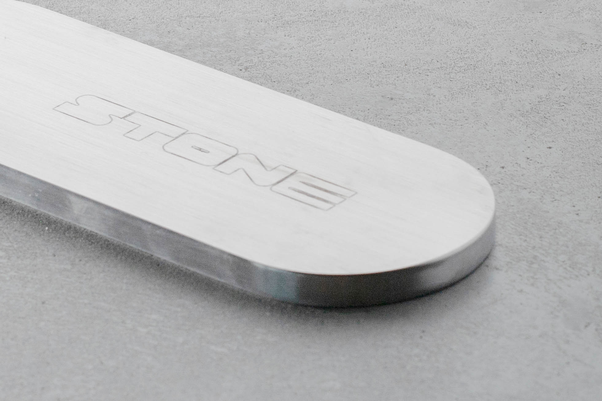 closeup of a metal incense holder, engraved with the word stone