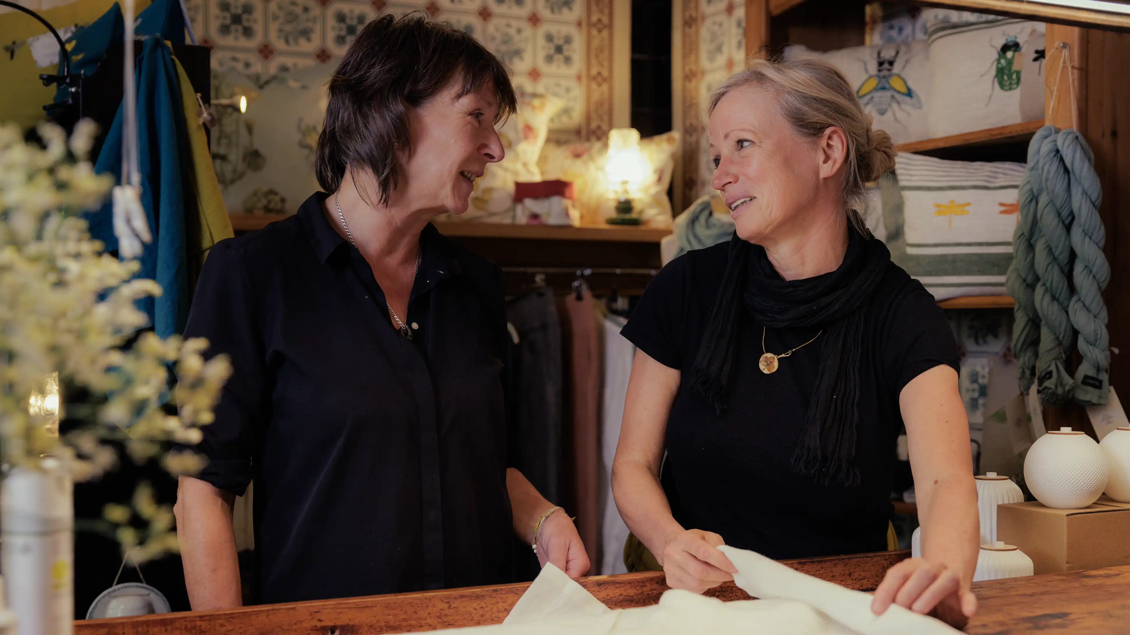 Zwei Frauen im Gespräch an einer Werkbank. Persönliche Beratung in gemütlicher Atelieratmosphäre.