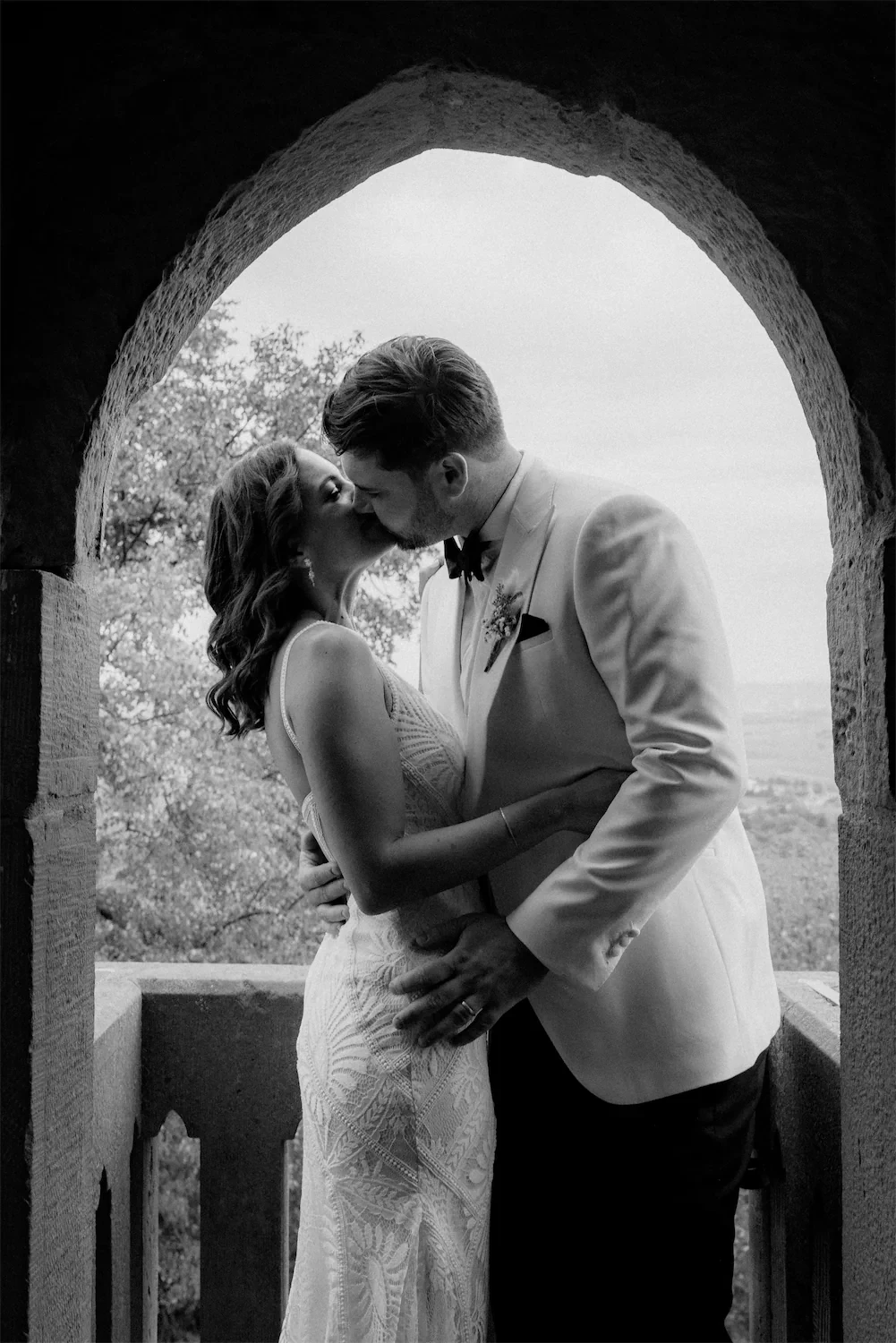 Couple kissing under flower blossom – Destination Wedding Photographer