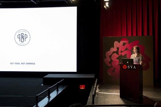 a woman giving a speech from a stand in the "designer as" thesis presentation