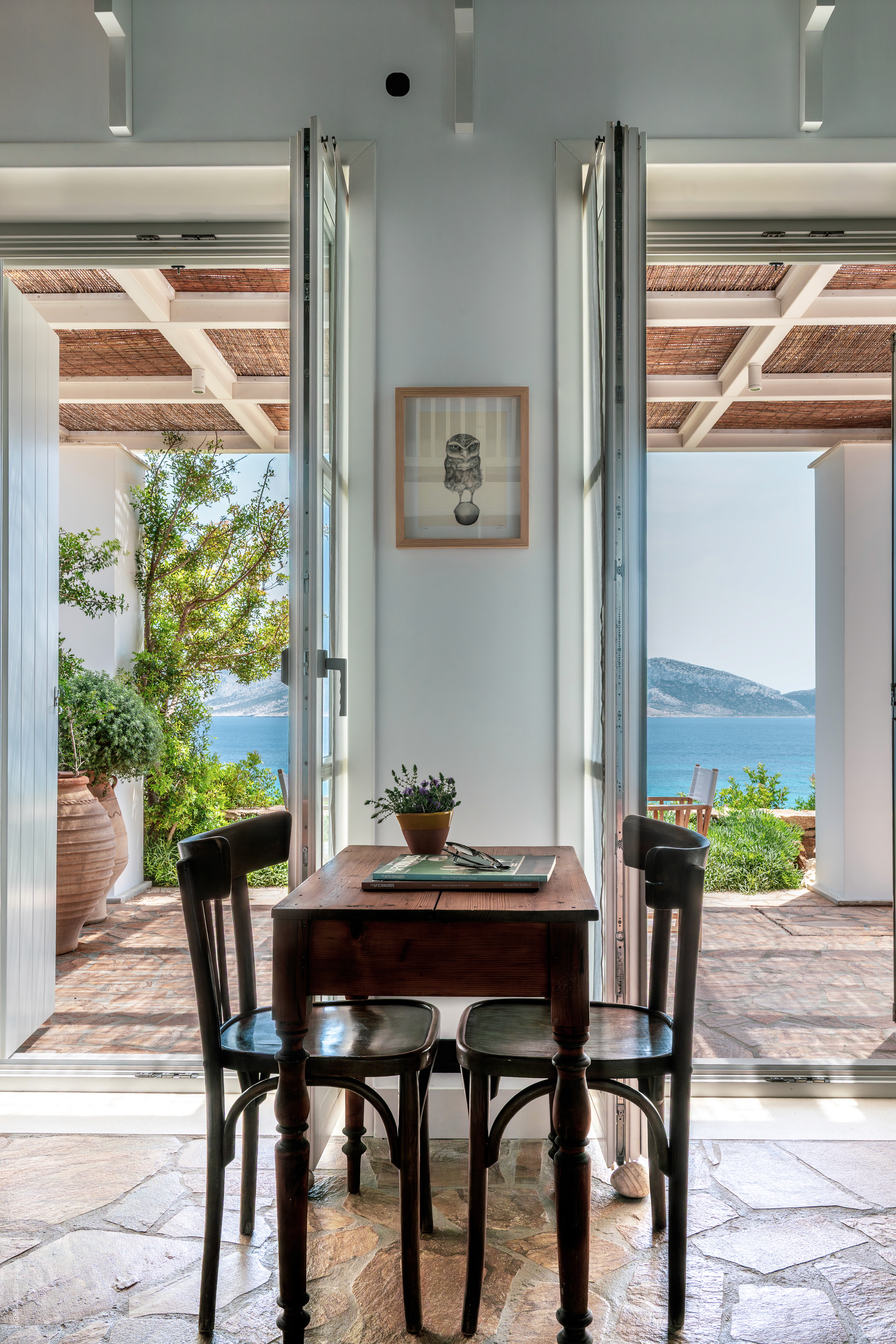 A living room featuring a wooden table and chairs looking out to a terreace.