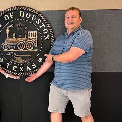 Lovely couple on the Astroville Tunnel Tour pose for picture with our city seal underneath Houston City Hall.