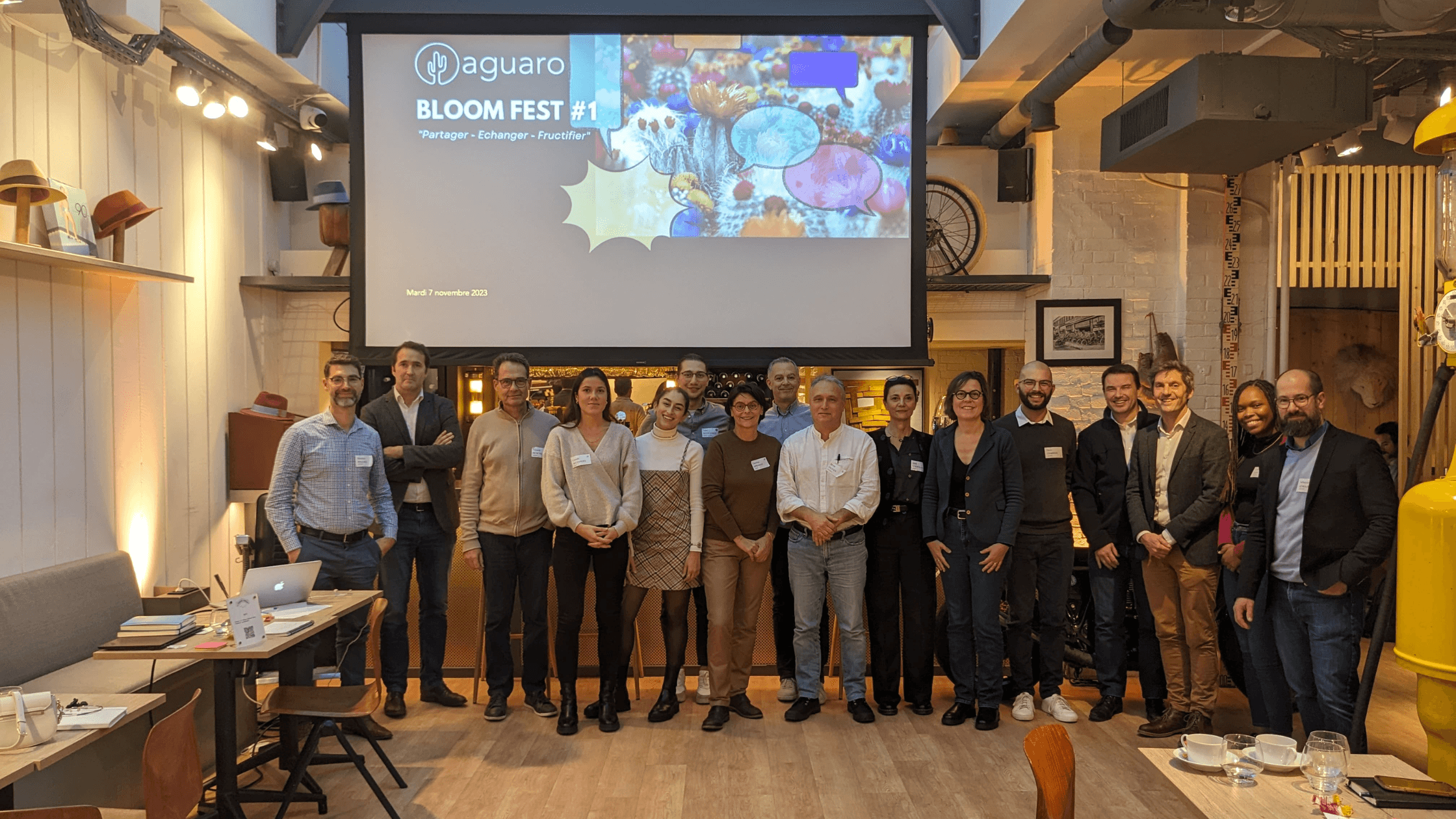 Photo de groupe des participants devant un écran lors de l'événement Bloom Fest #1 d'Aguaro, qui s'est tenu le 7 novembre 2023.