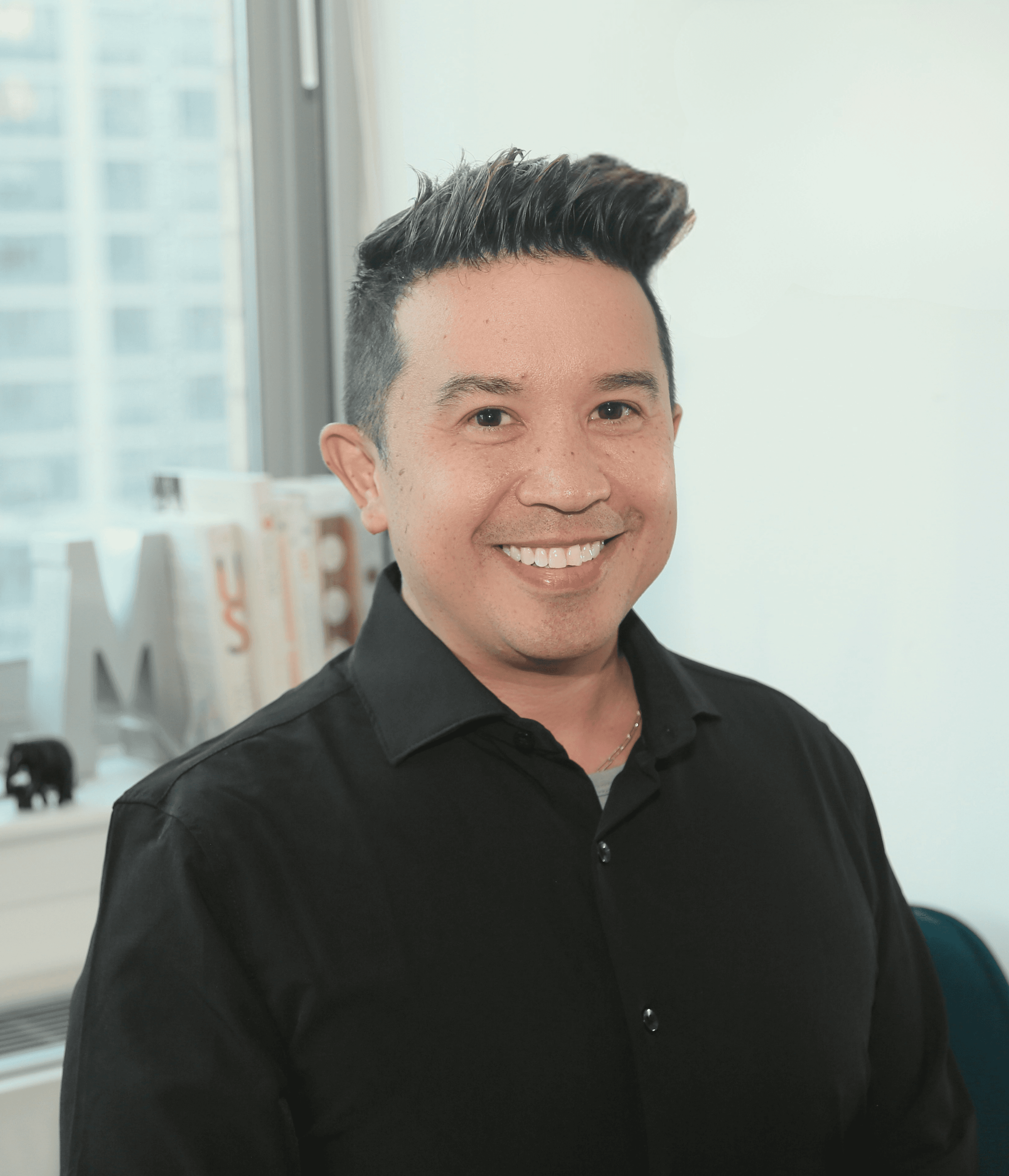 Professional headshot of a business advisor in a white shirt, smiling confidently against a warm neutral background.