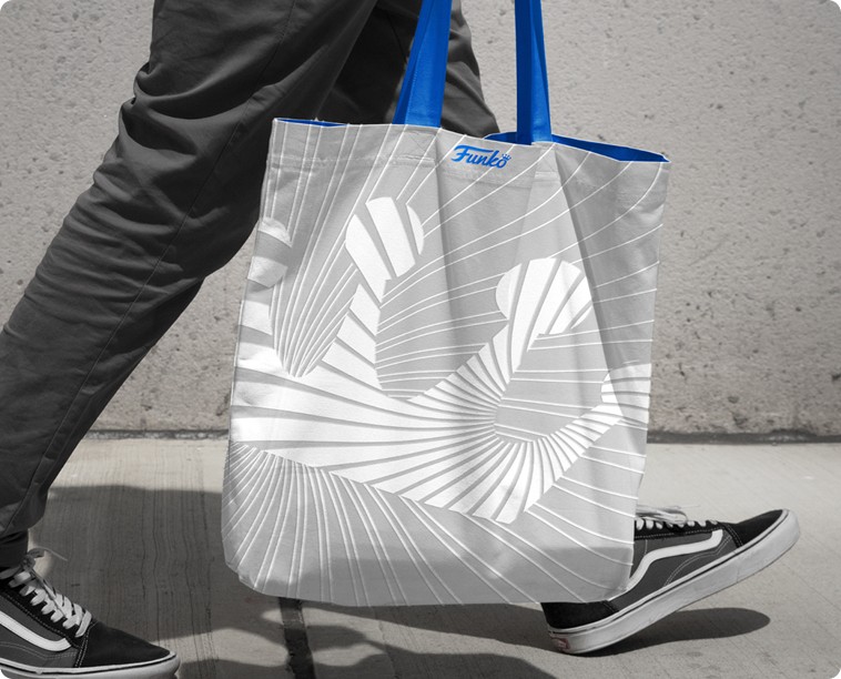 A person carries a canvas tote branded with the Funko crown