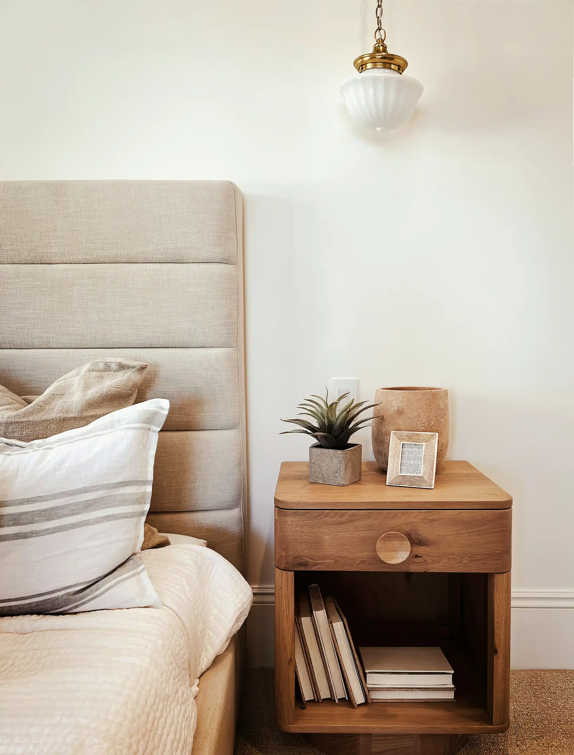 Modern bedroom with a neatly made bed, soft lighting, and minimal decor