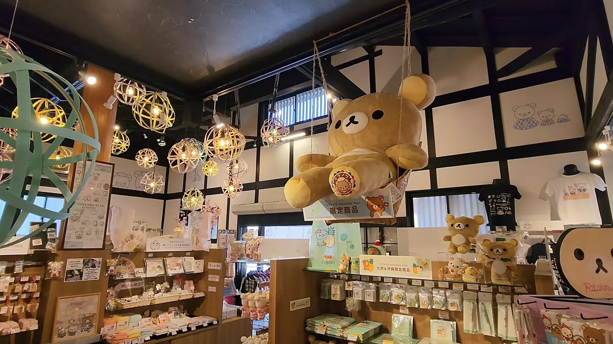 Inside a souvenir shop at Kurokawa Onsen, woven lantern spheres hung above shelves of gifts