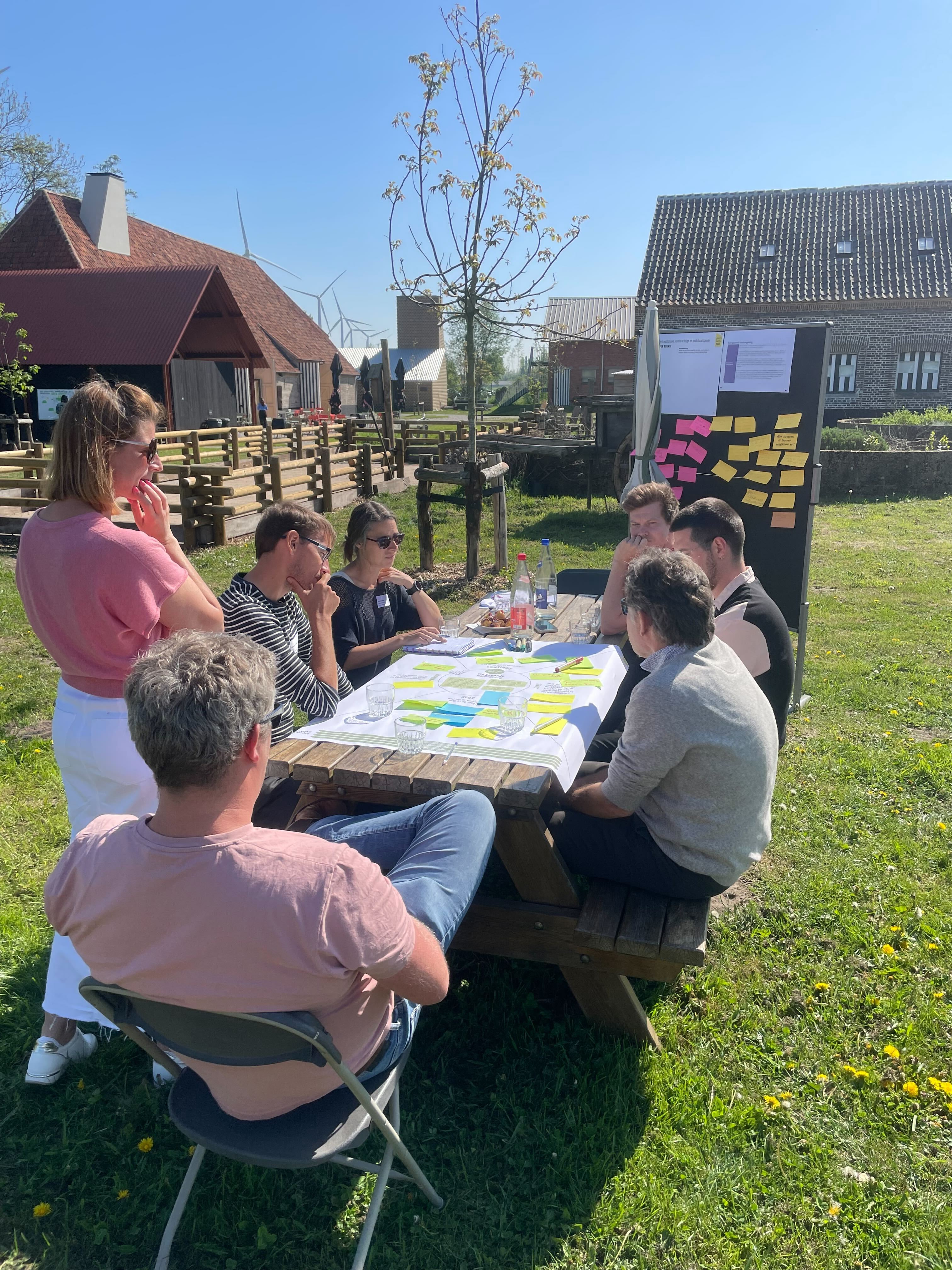 You can barely see the phone recording the session with Dembrane and sending insights live to the host.