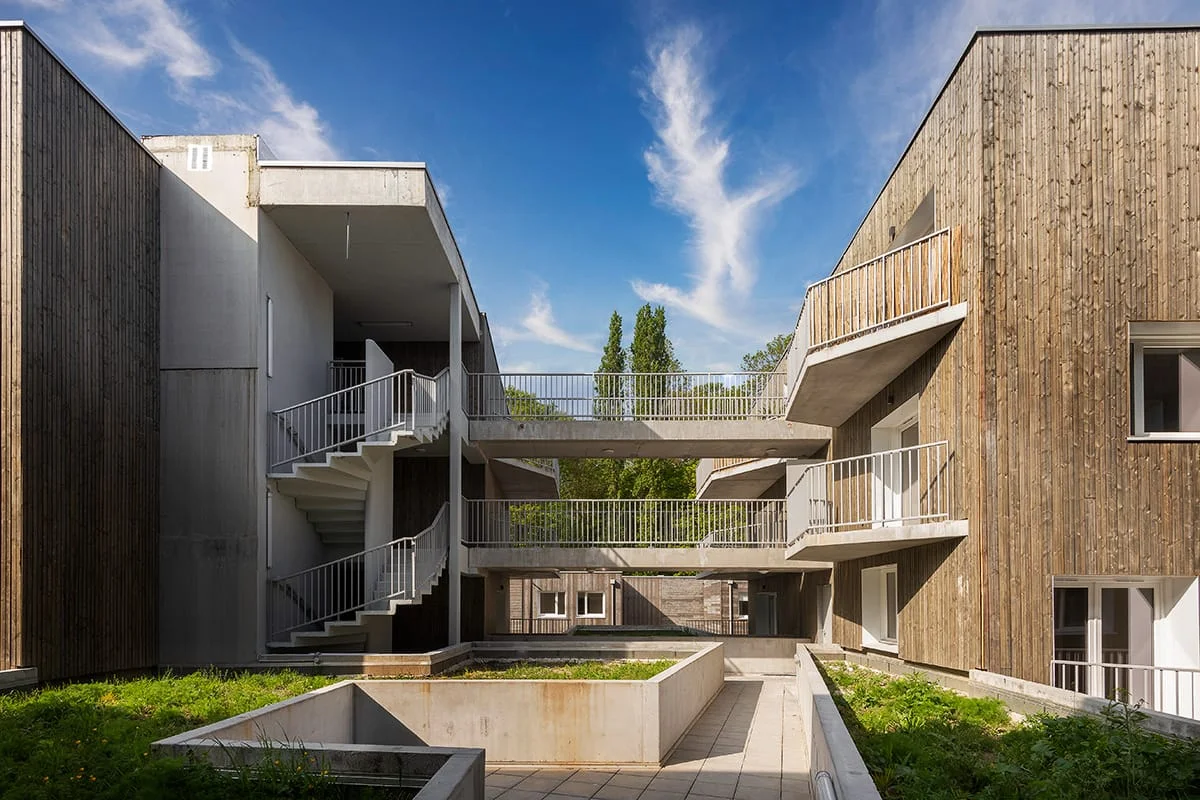 Patio résidentiel en bois et béton avec coursives extérieures — architecture durable à Lille (Nord)