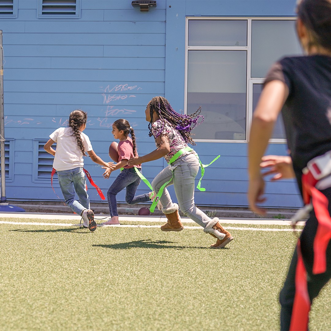 Students practicing passing and catching skills in a structured flag football enrichment class