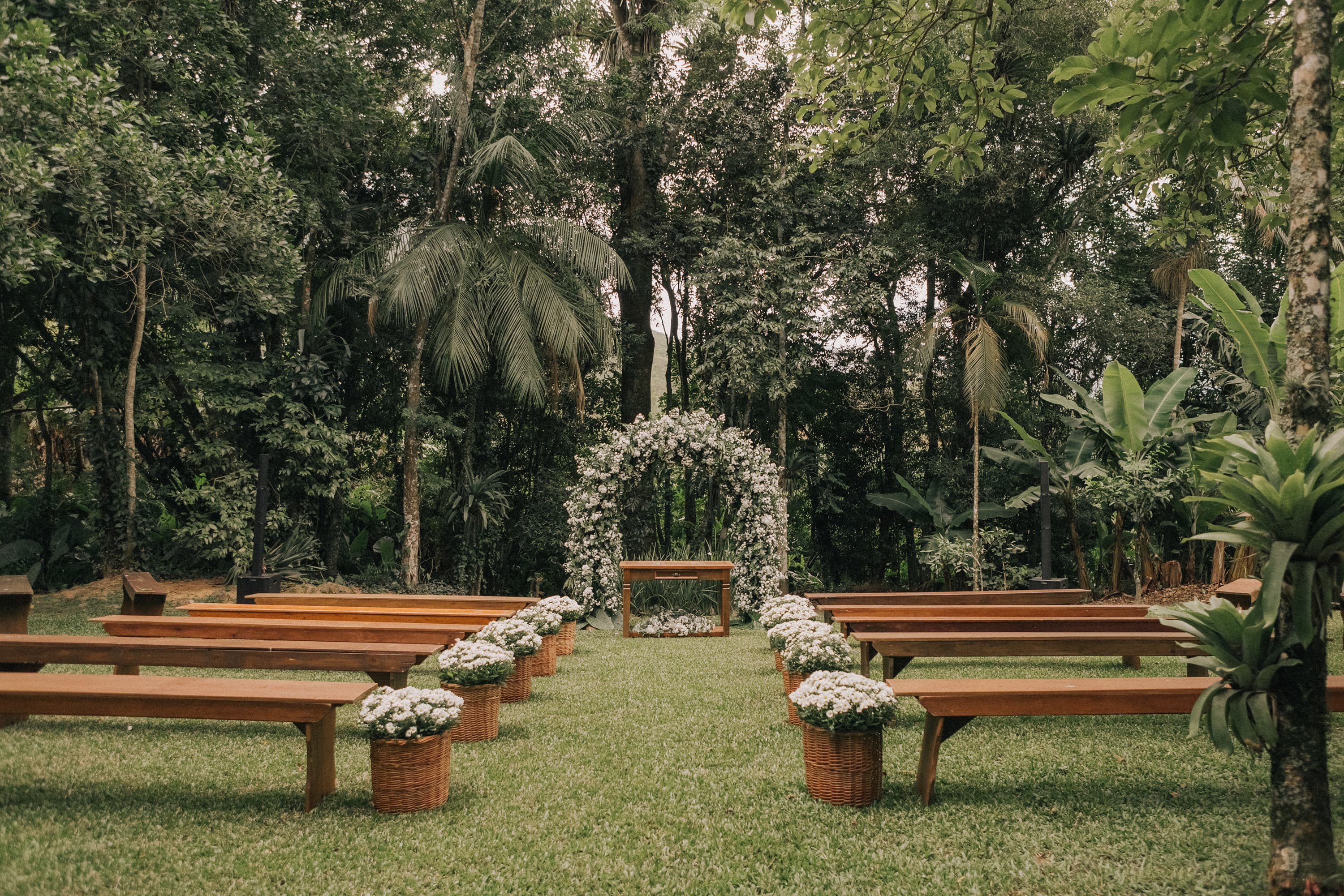 Altar casamento outdor, em jardim com bancos e decoração em flores