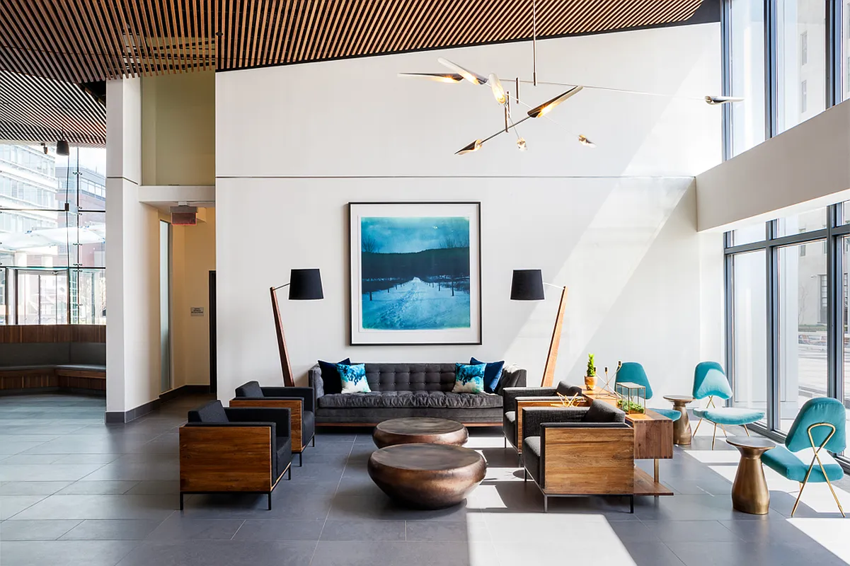 Stylish lobby showcasing blue chairs and a significant large painting, contributing to a modern design ambiance.