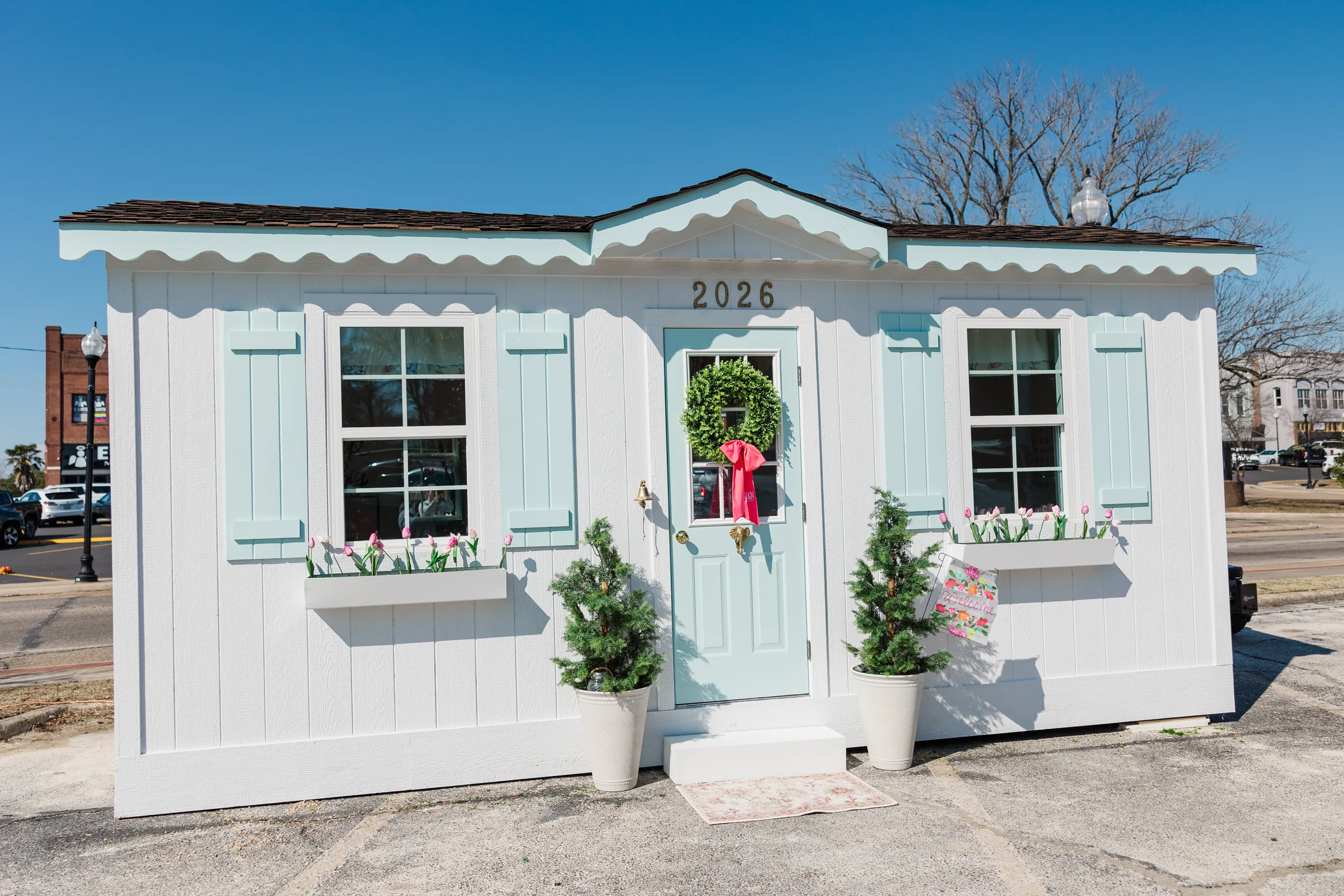 Vibrant tablescape by Sarah Overall Events with pink scalloped napkins, gold flatware, personalized place settings, and colorful floral arrangements in Shreveport.