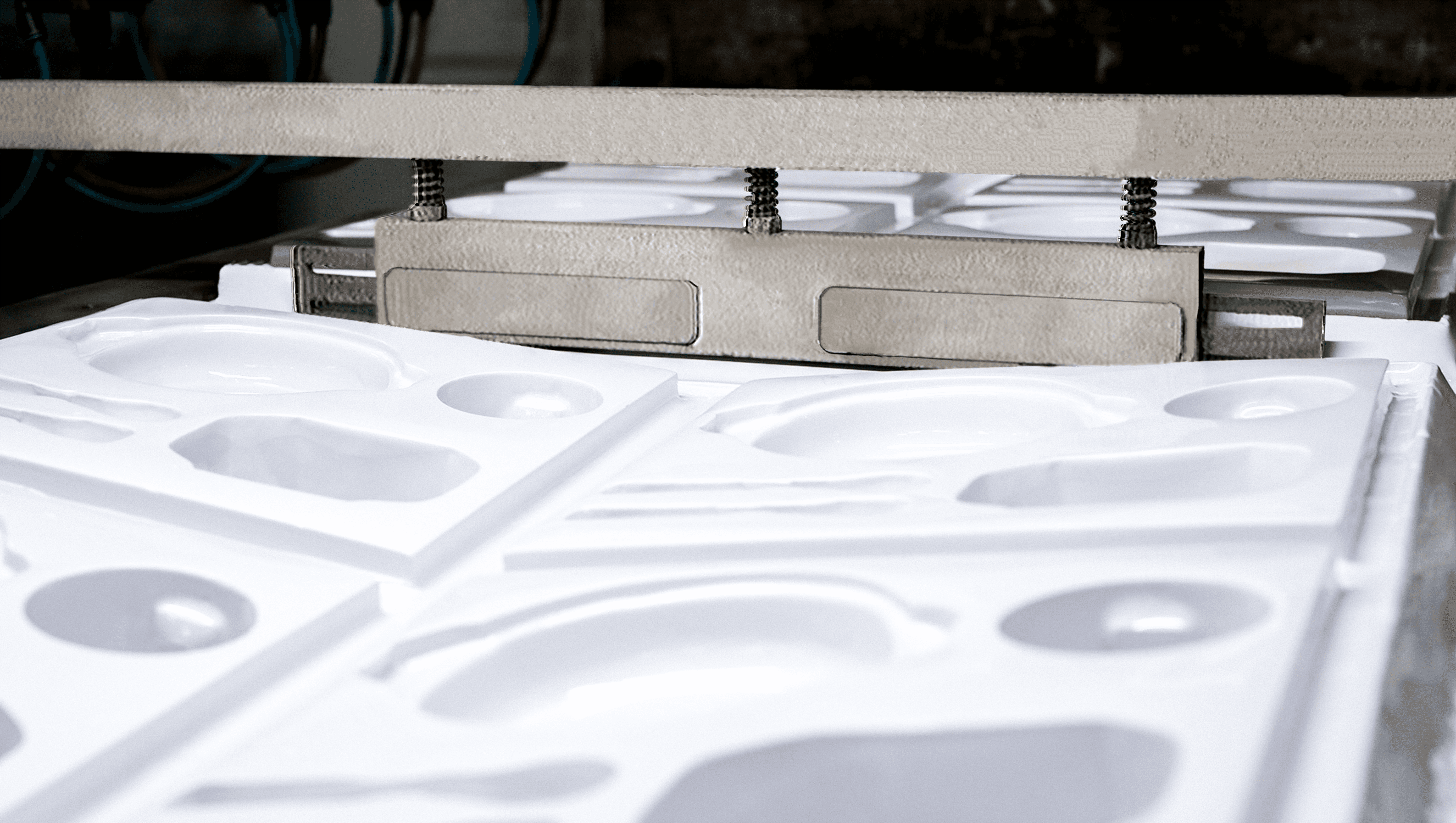 Mesin otomatis sedang melakukan proses pembentukan dan pemotongan lembaran plastik untuk kemasan, menunjukkan cetakan presisi dan hasil potongan rapi di lini produksi pabrik kemasan plastik.