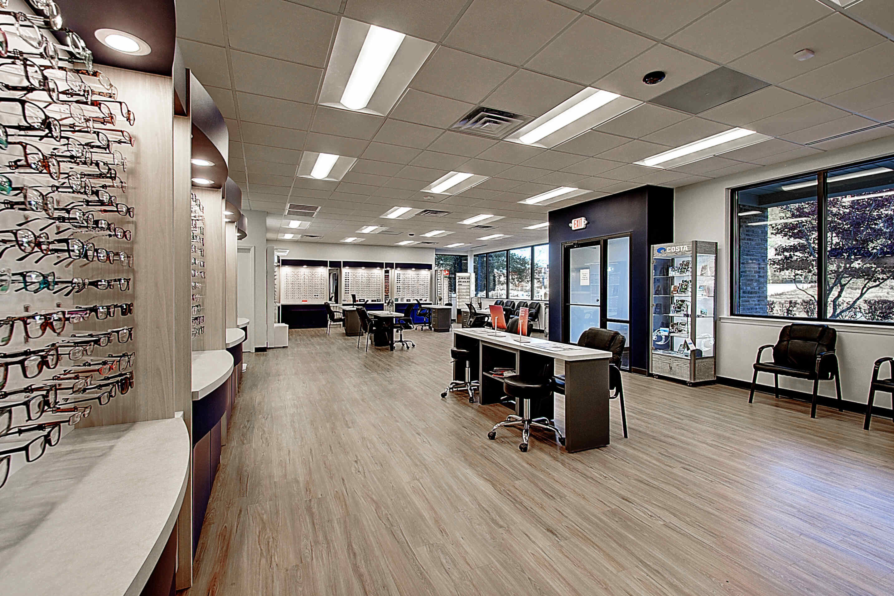 A bright, modern interior view of a spacious shop with tables and display shelves.