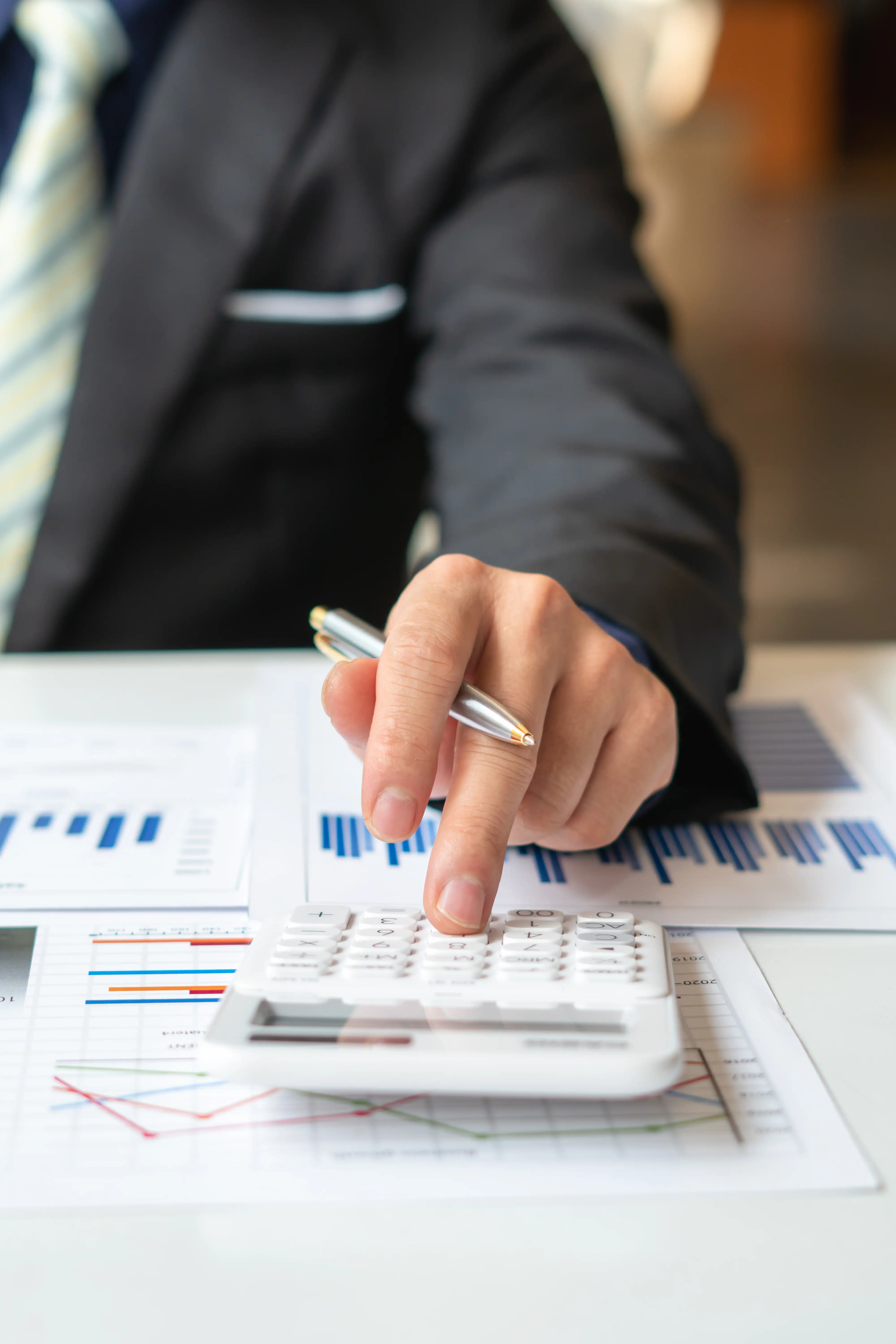 Professional using a calculator over financial reports to calculate double damages and lost wages under California Labor Code Section 972