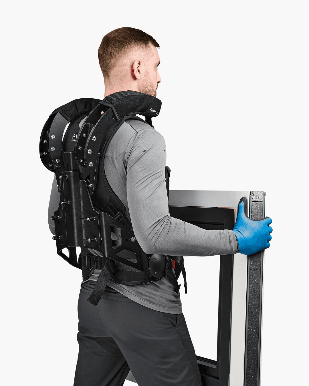 Homme utilisant le CarrySuit pour transporter une charge lourde, conçu pour soulager les épaules et le dos lors des travaux physiques.
