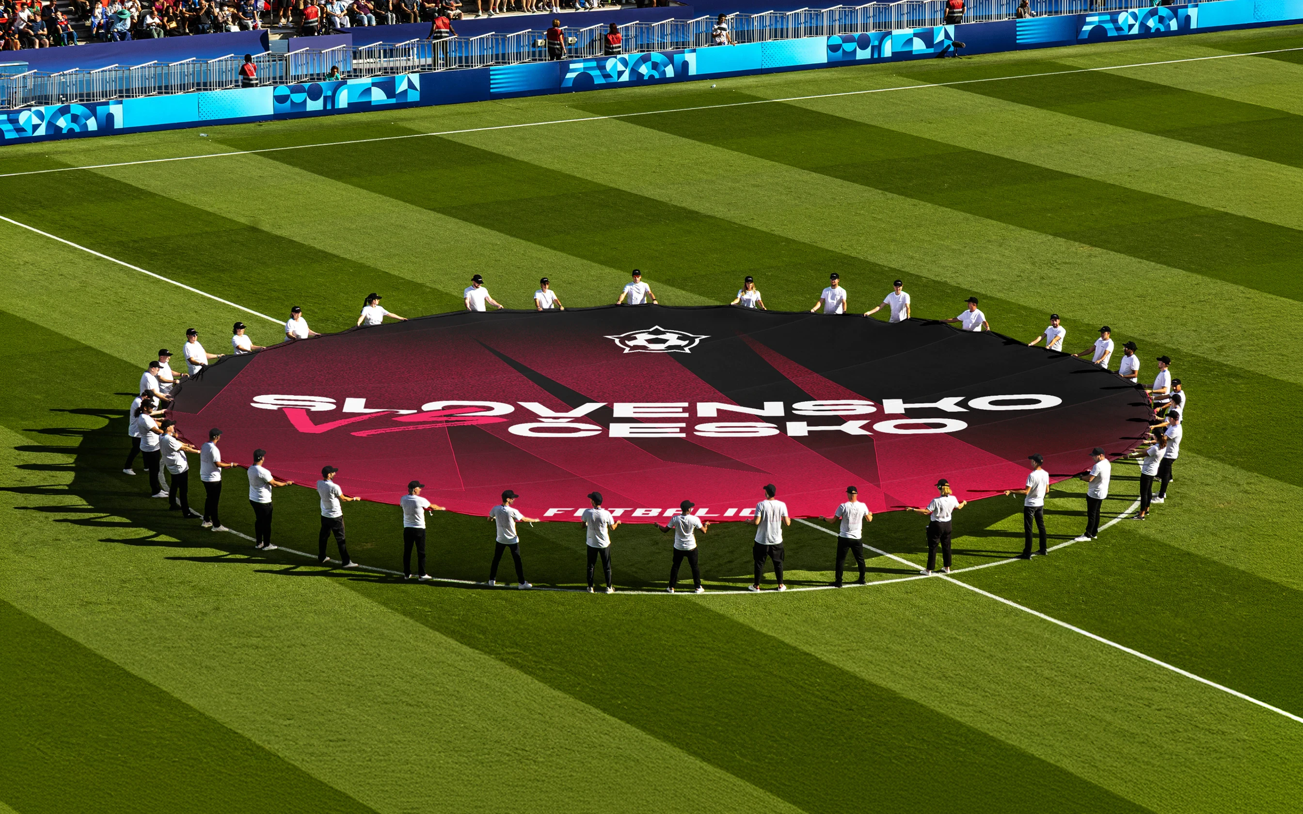 Futbalic match kickoff branding graphics in the middle of a football pitch.