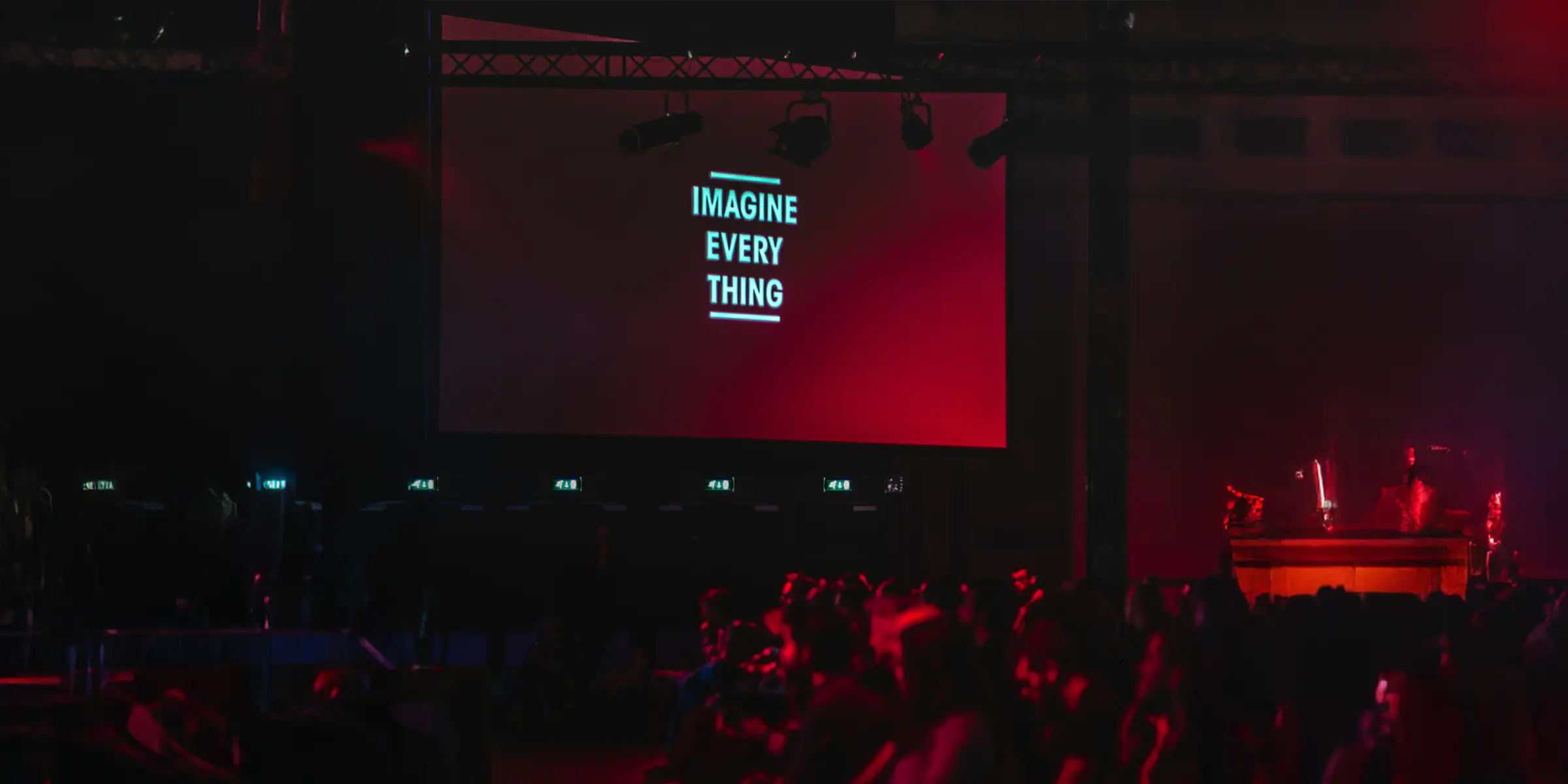 picture of someone presenting to an audience with the presentation text "imagine every thing" on a large screen