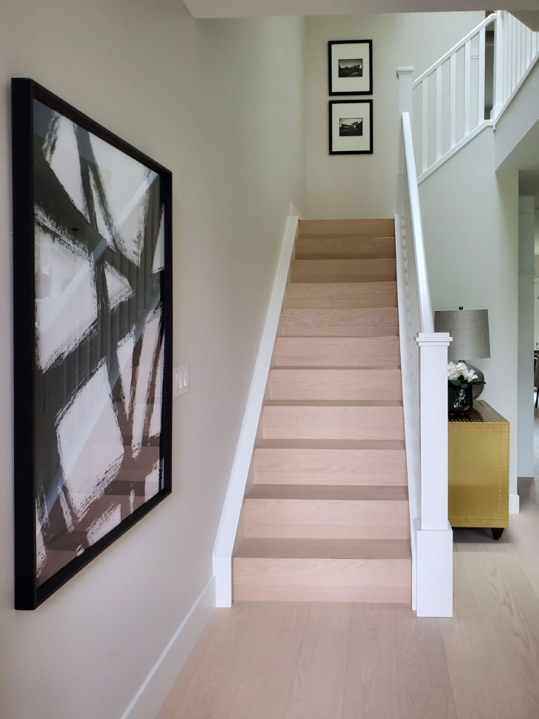Image of KHD Homes interior design featuring a staircase with light wood steps and white railings.