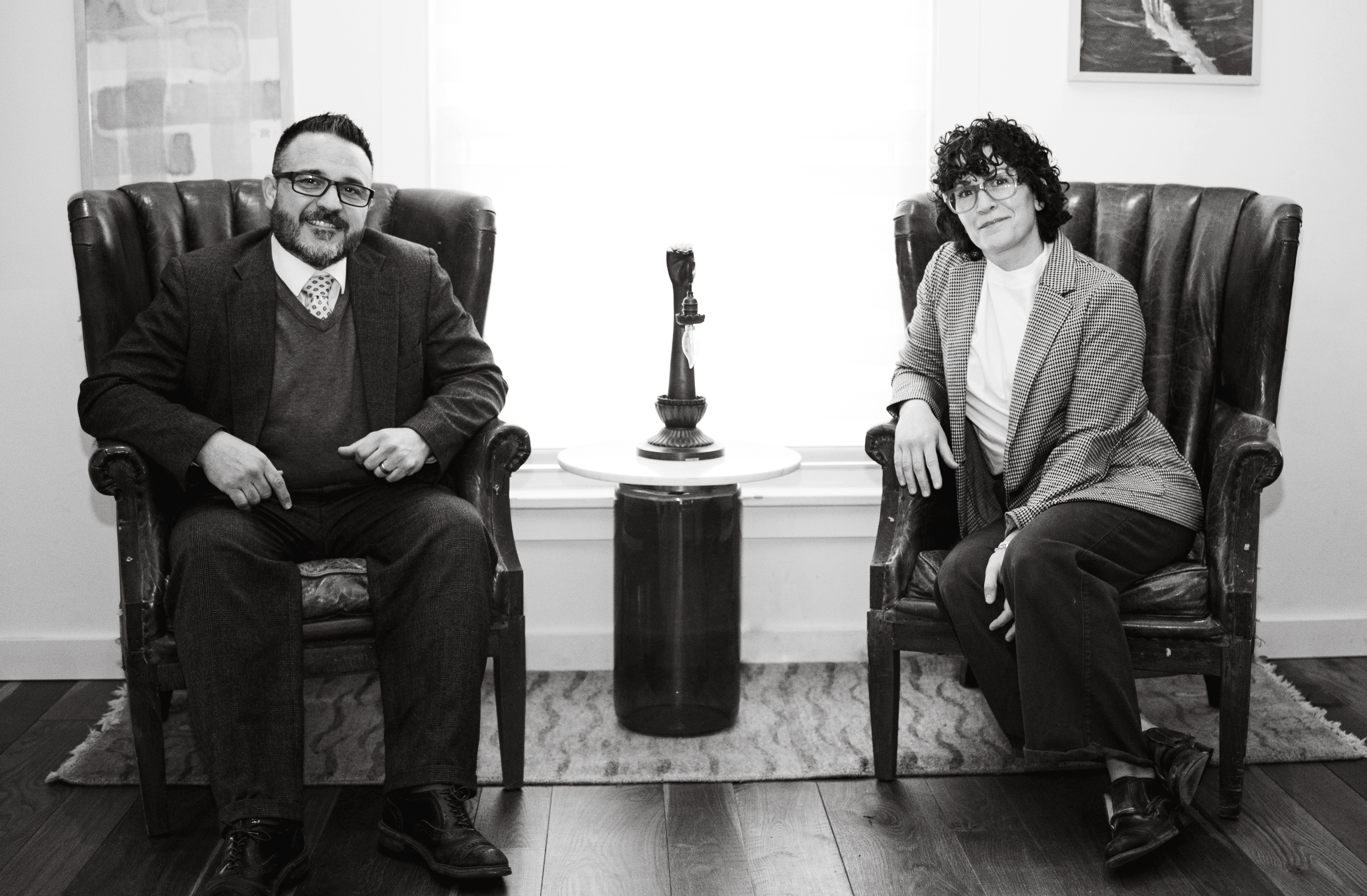 Man and woman shaking hands in formal business attire, lawyers