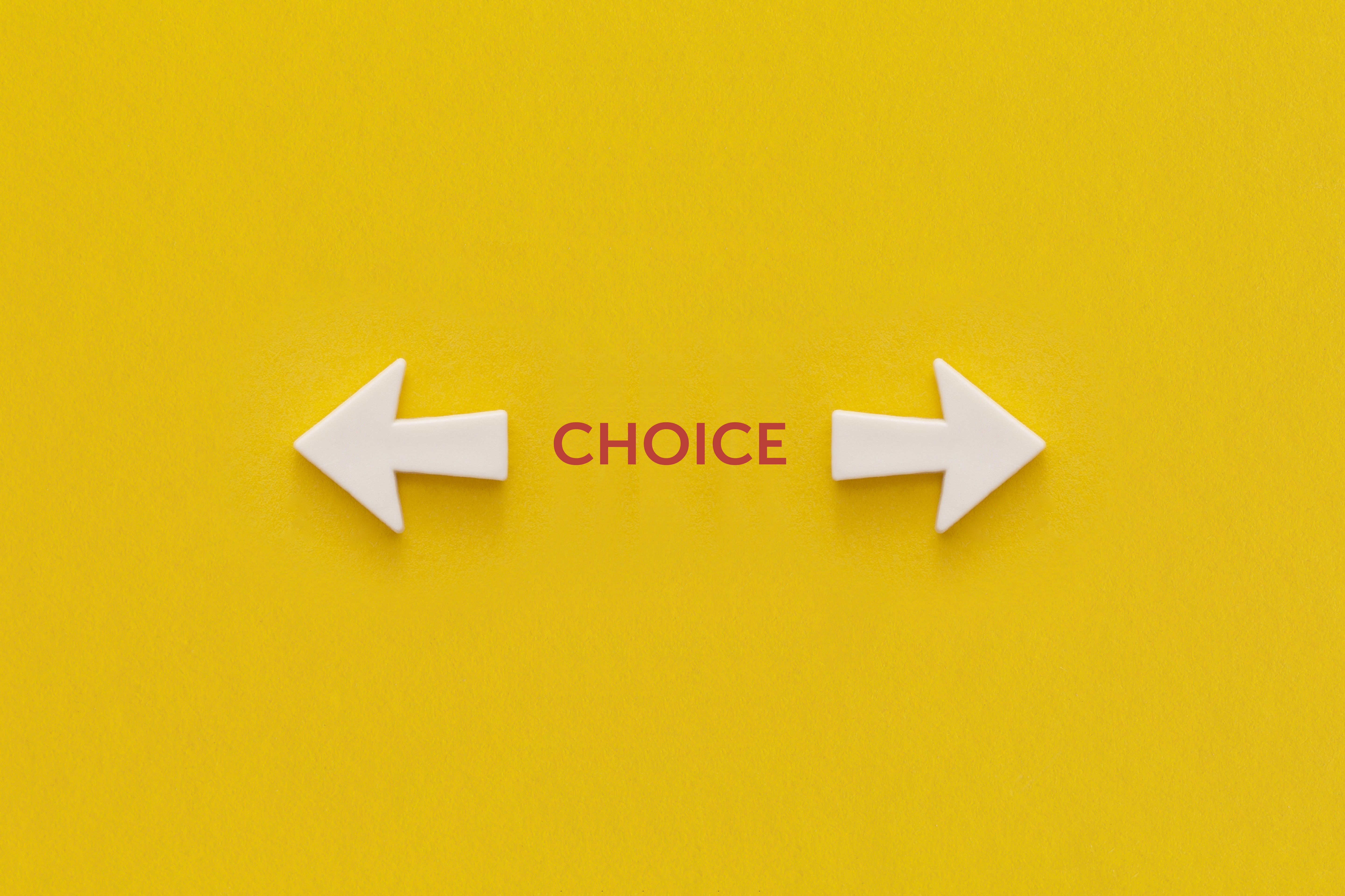 Two white arrows pointing in opposite directions with the word Choice between them on a yellow background, representing the decision service business owners face when evaluating whether they are ready to invest in a marketing system or need to address foundational issues first
