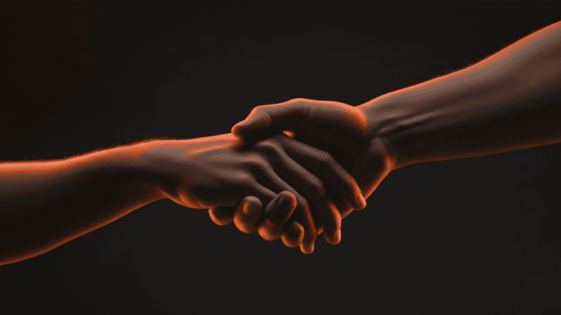 Looking at this image, here's alt text that captures both the visual and thematic elements: Concise version: "Two hands clasping together in a warm, supportive handshake illuminated by orange light against a dark background