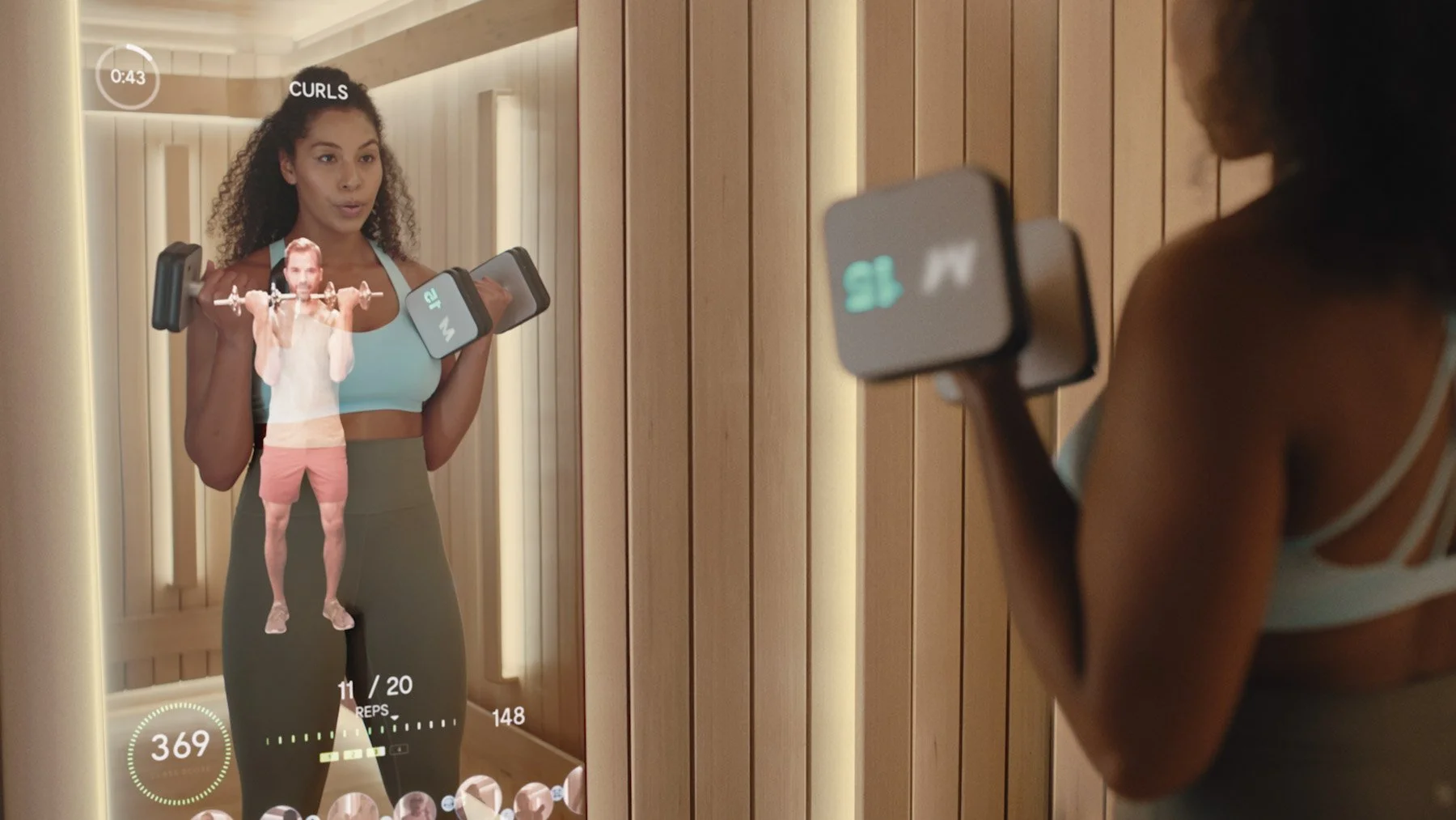 Person performing dumbbell curls with Mirror smart weights in front of the connected fitness mirror