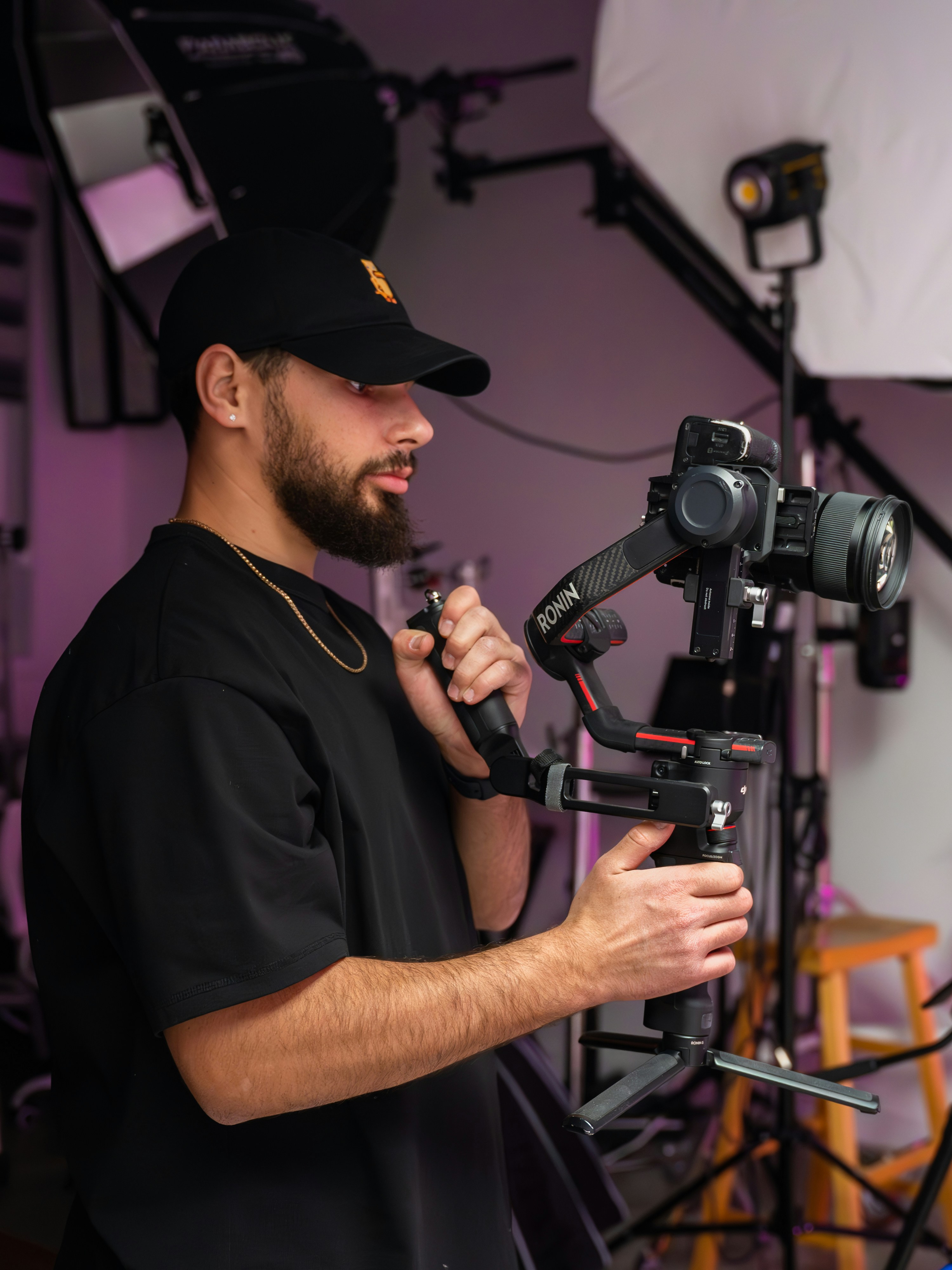 Man films using a camera stabilizer in a studio.