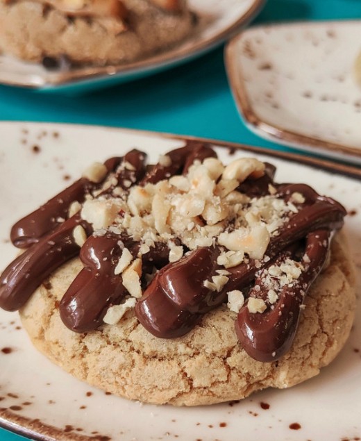 Benidorm artisan cookie topped with crushed hazelnuts and chocolate drizzle