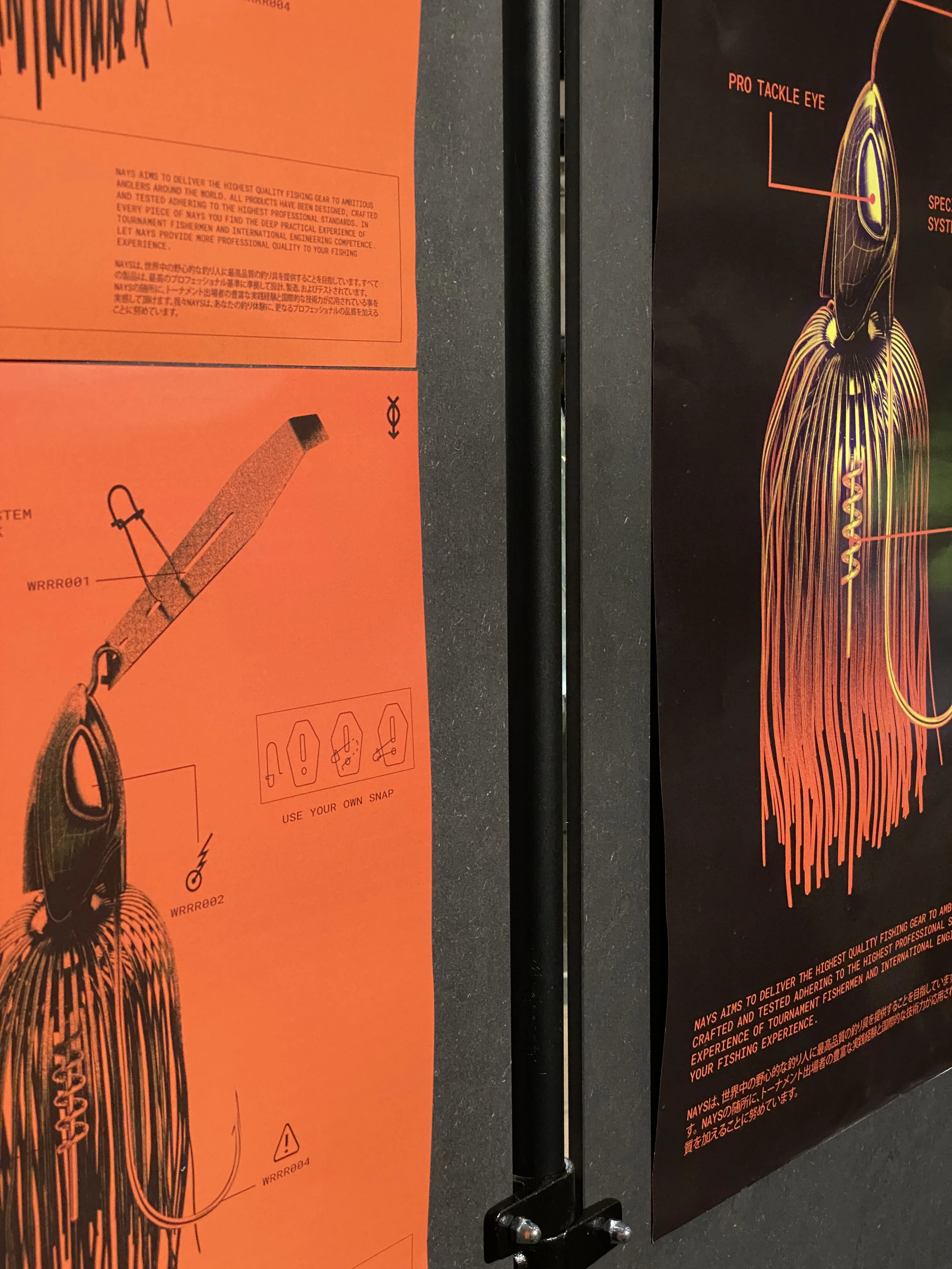 Orange and black technical posters with detailed drawings of Nays fishing lures and Japanese typography.