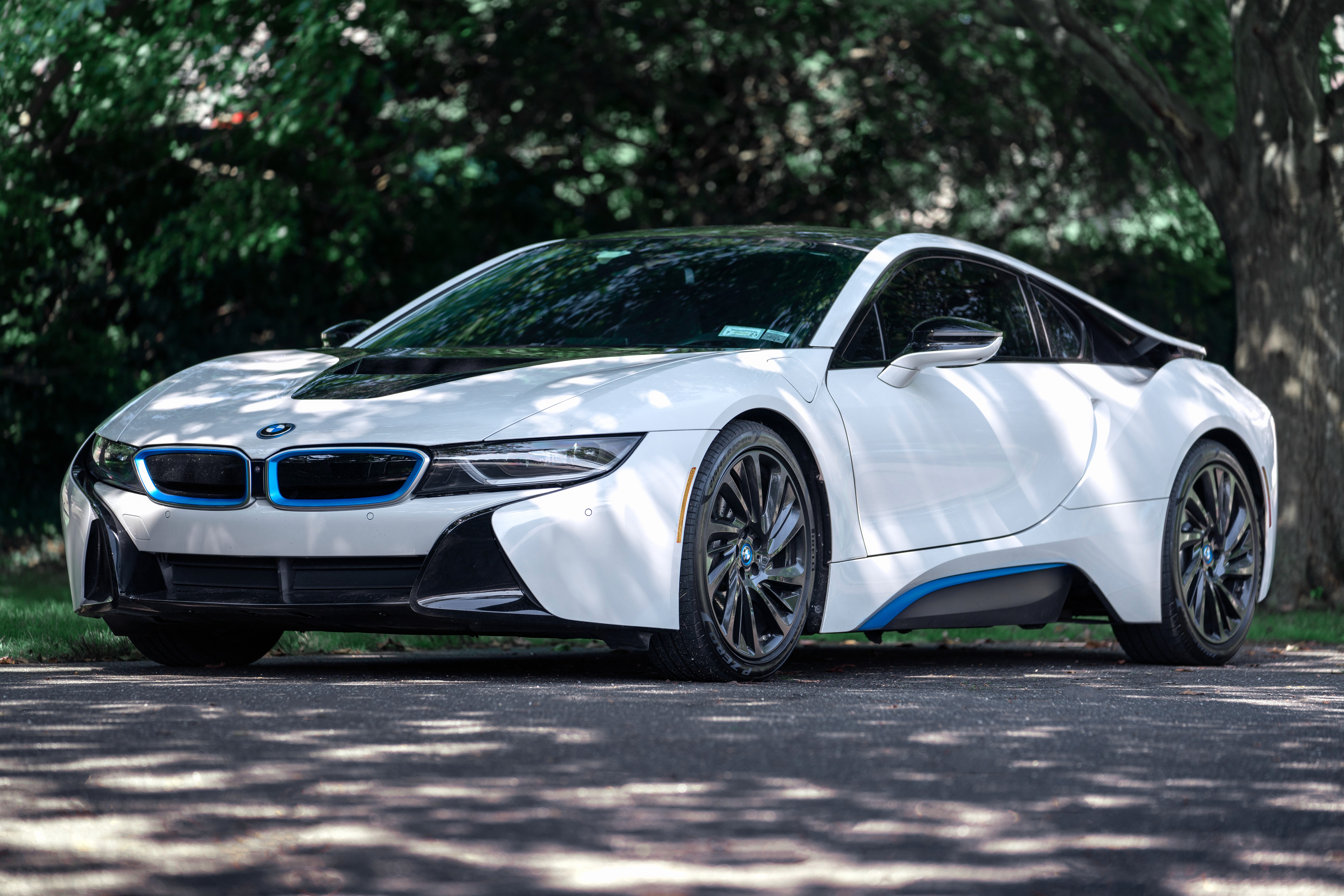 Rear-side view of the BMW i8 surrounded by palm trees, capturing its exotic styling and tropical Miami backdrop.
