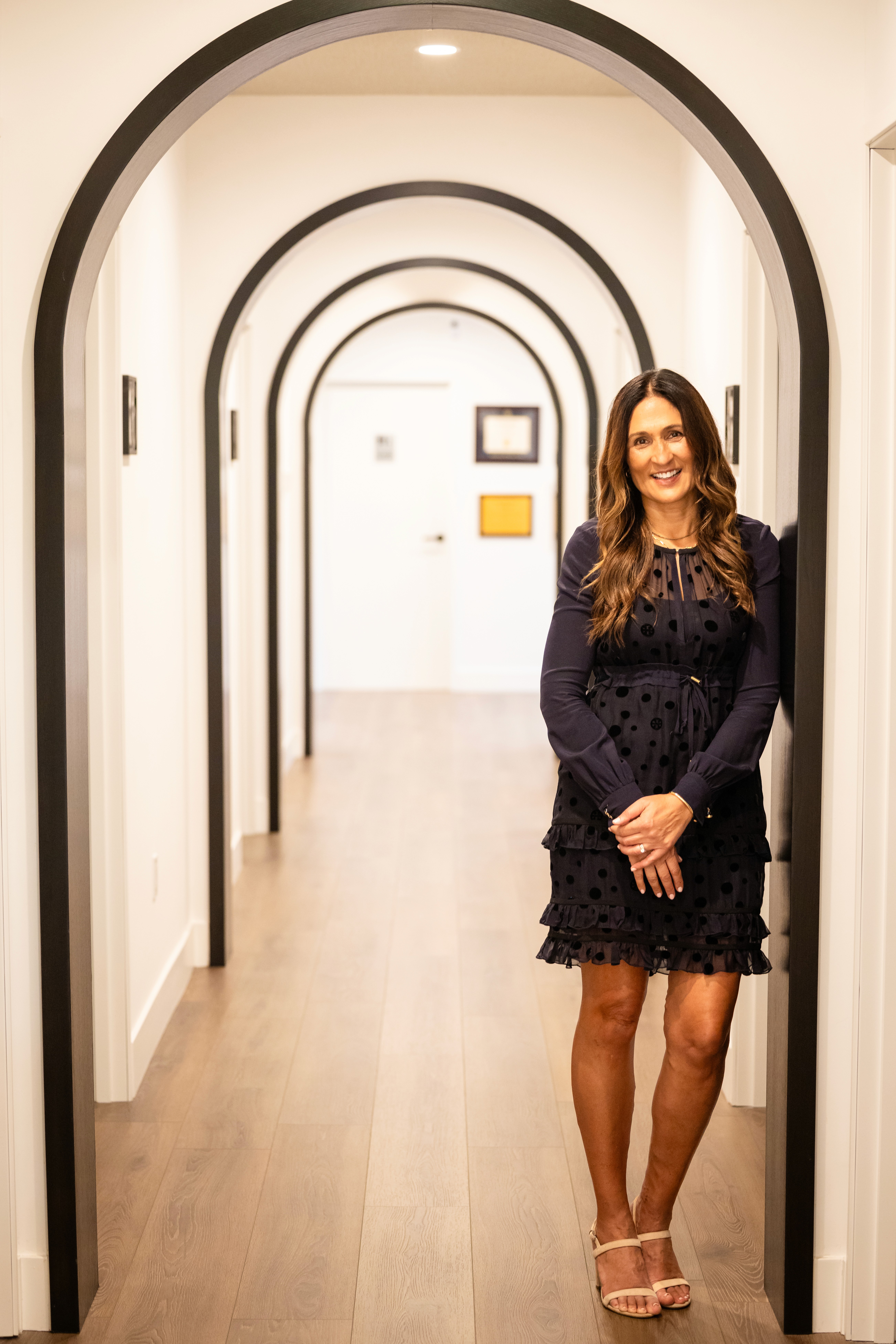 a woman wearing a white dress and gold hoop earrings