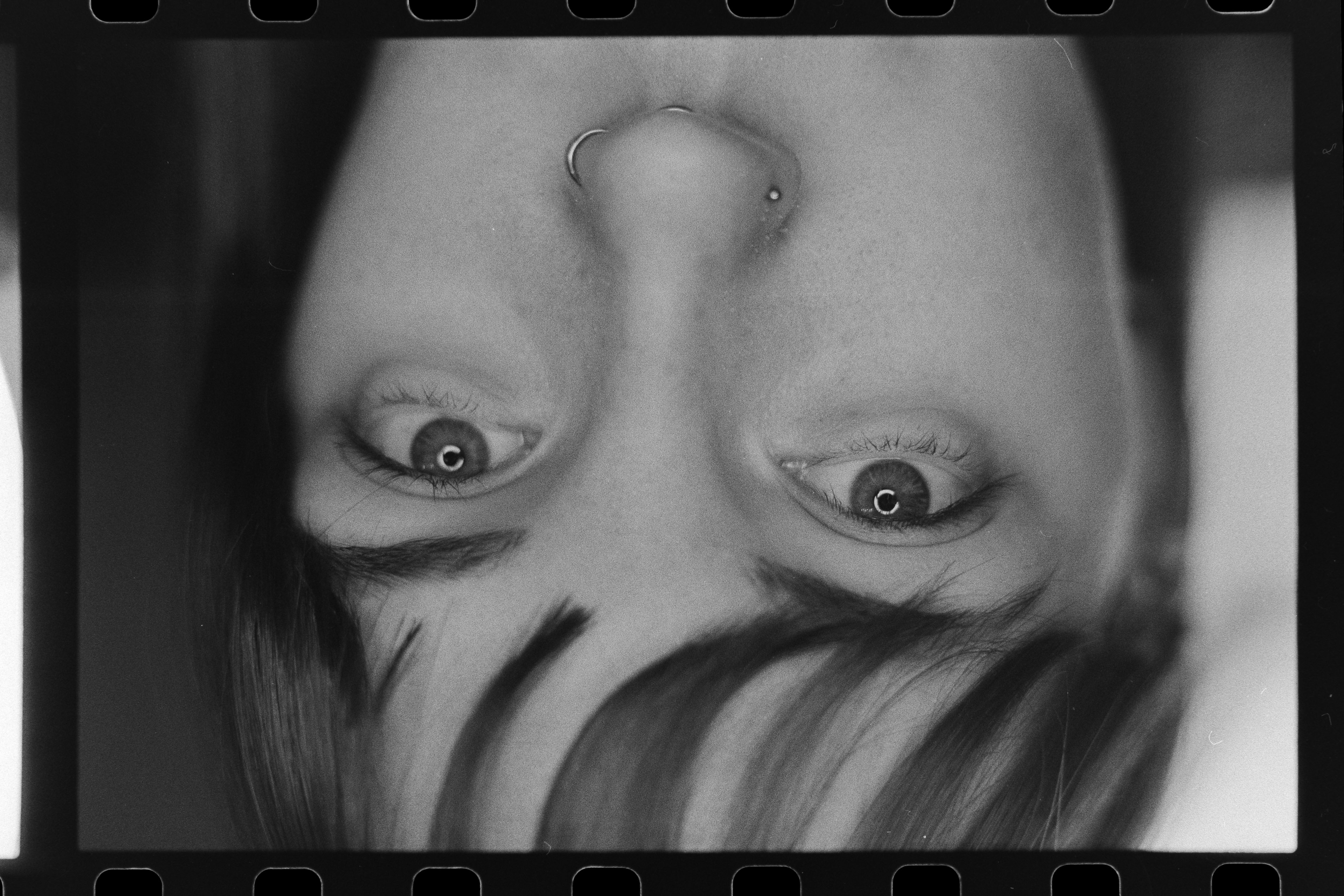 Close-up of a yellow tennis ball sitting on a green court, positioned near the white center line.