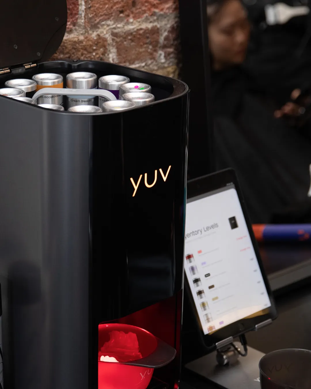 The yuv® Lab with the lid open alongside the app instructing the colourist to change the cartridge.