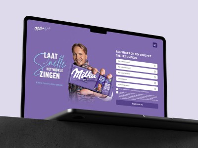 man wearing grey t-shirt standing in front of man sitting on chair