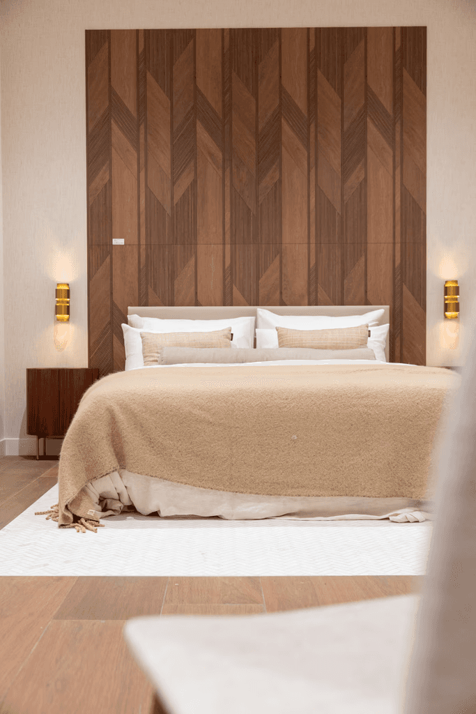Man and woman standing together at a desk with a laptop and notebooks, smiling at the camera.
