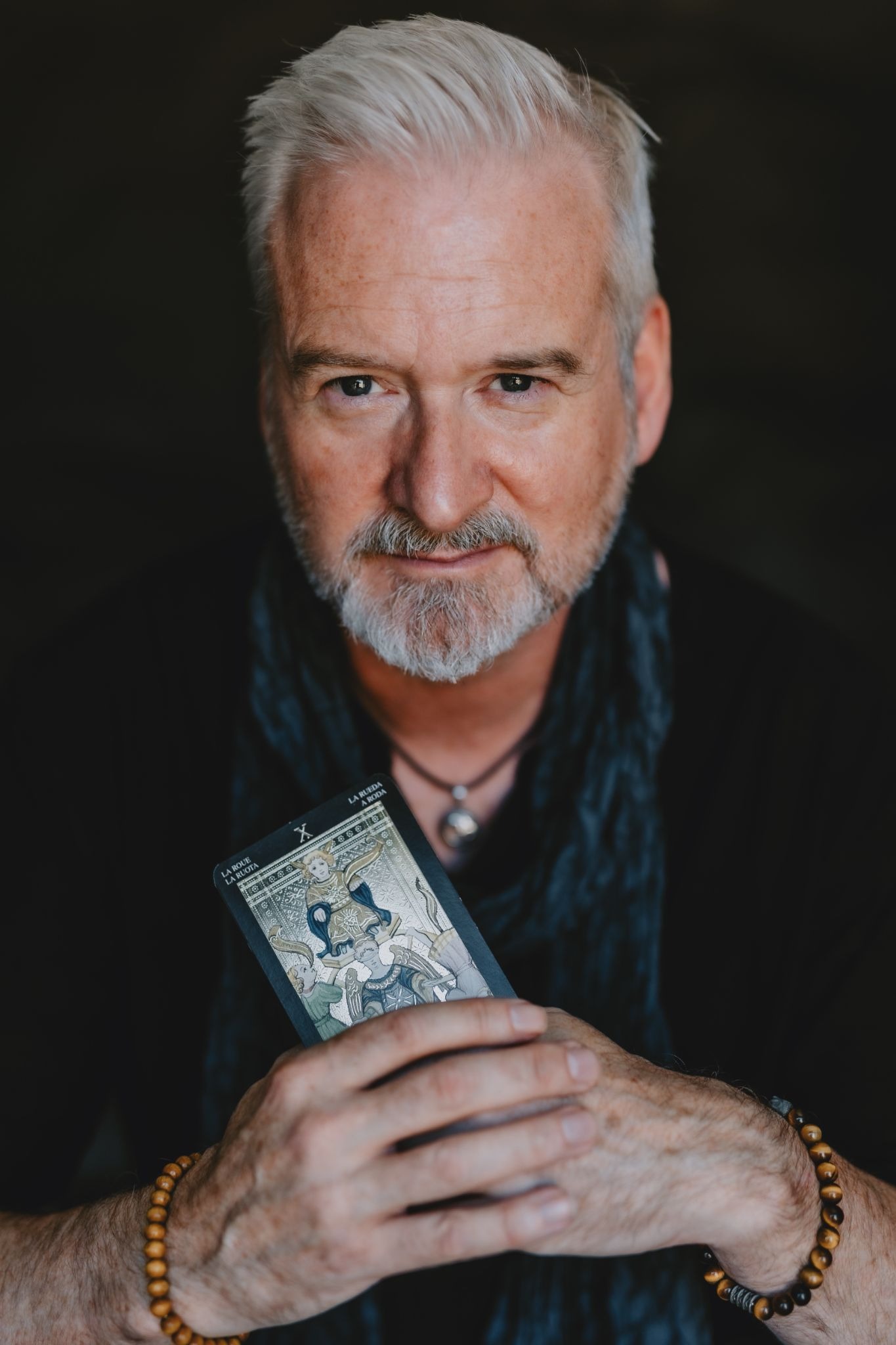 Richard Knight holding a Tarot card during a portrait, representing his modern, educational approach to Tarot.