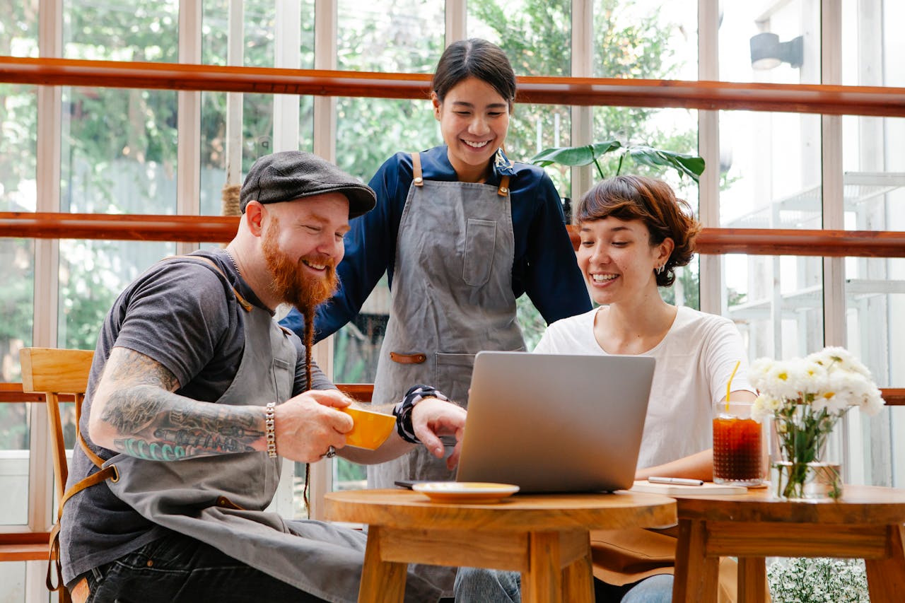 Compañeros trabajando con una computadora portátil en una cafetería