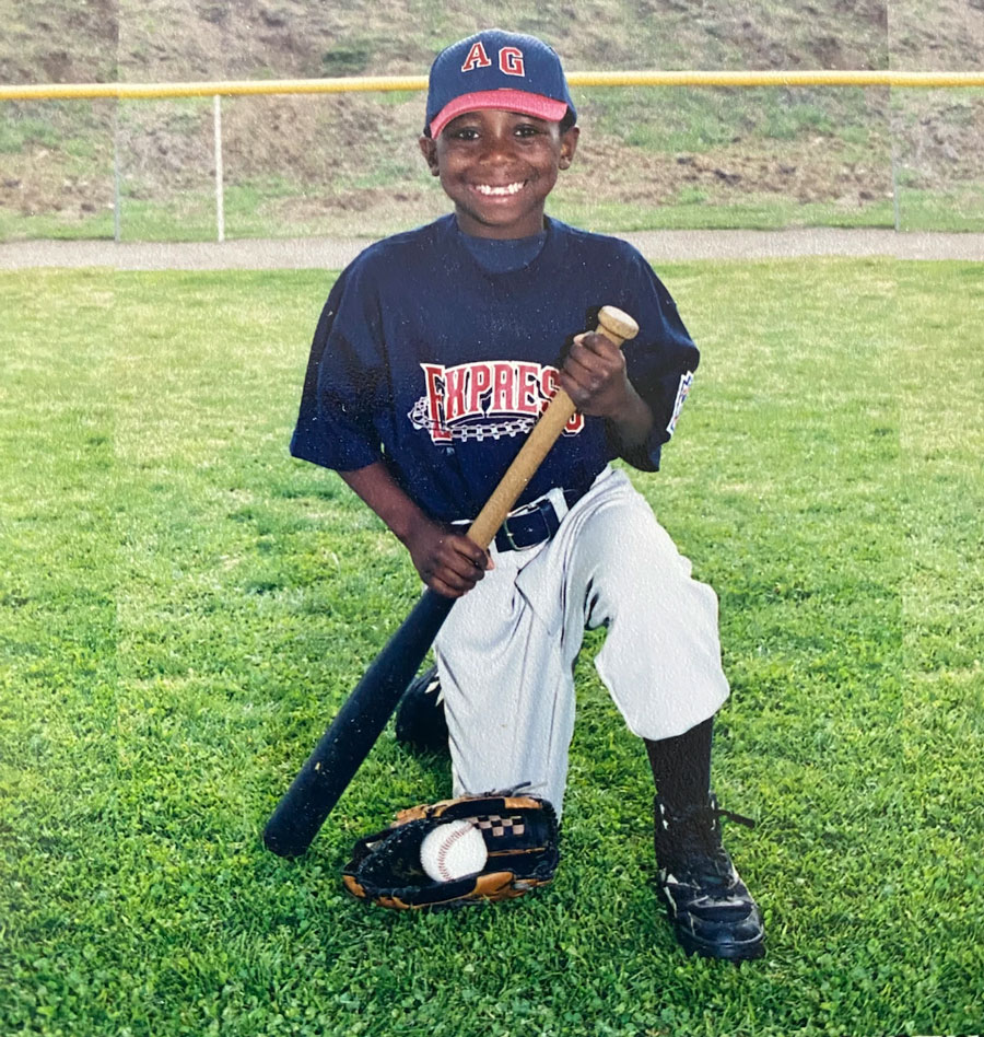 Junior Coleman posing with a baseball bat as a young player in little league