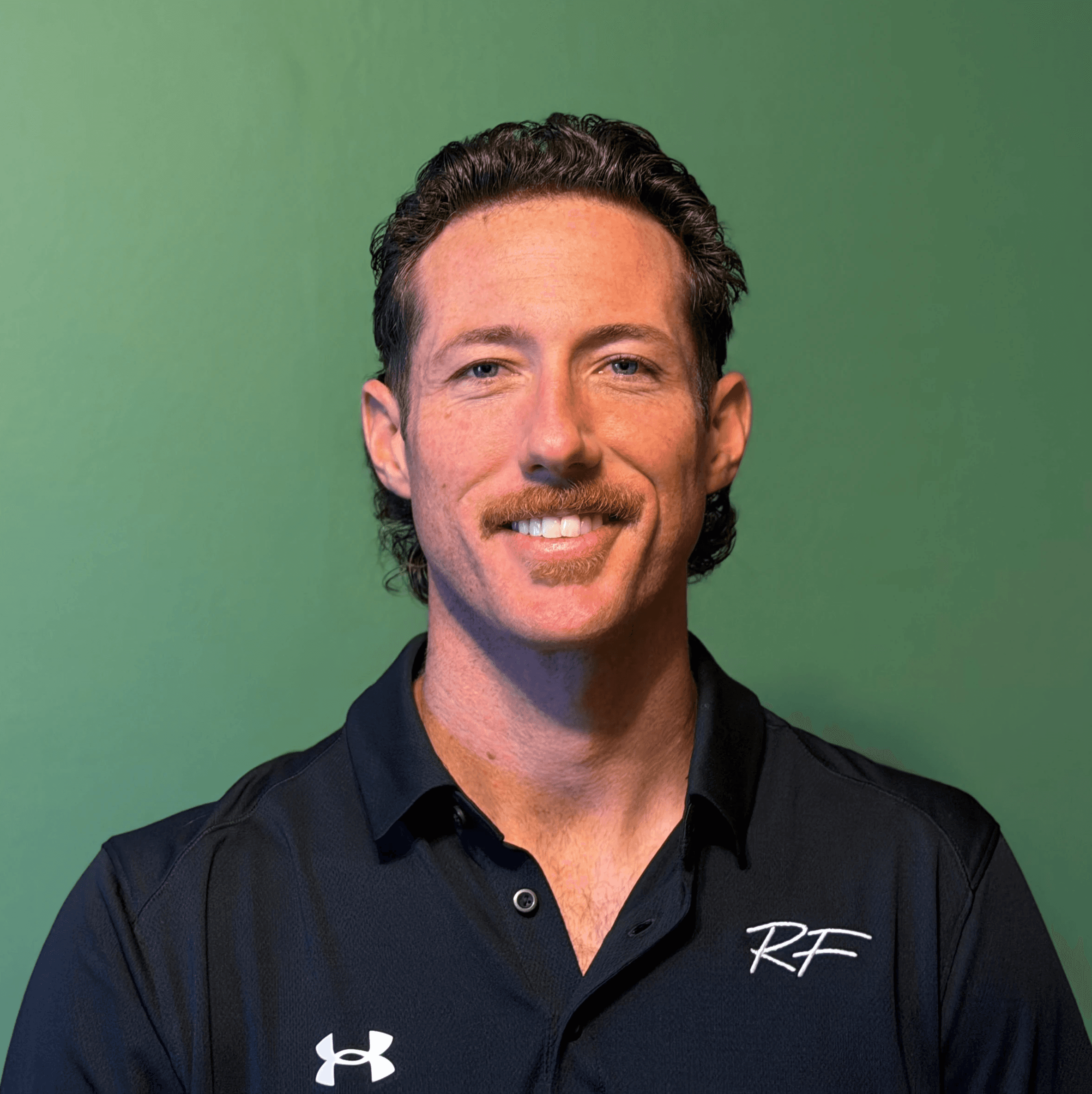 Man in black track suit on a track. Coaching or athlete.