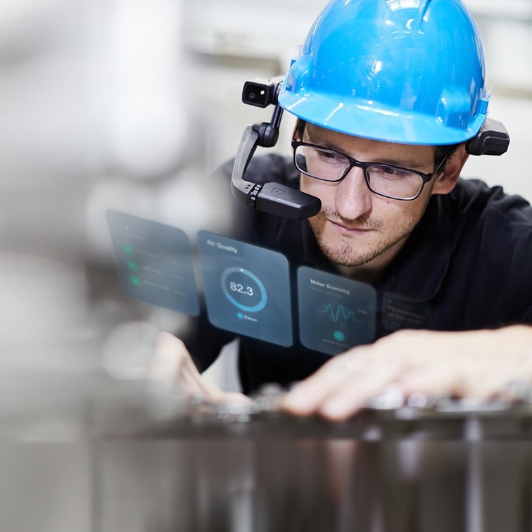 A photo of an engineer wearing a RealWear headset and being guide to do his job by augmented reality