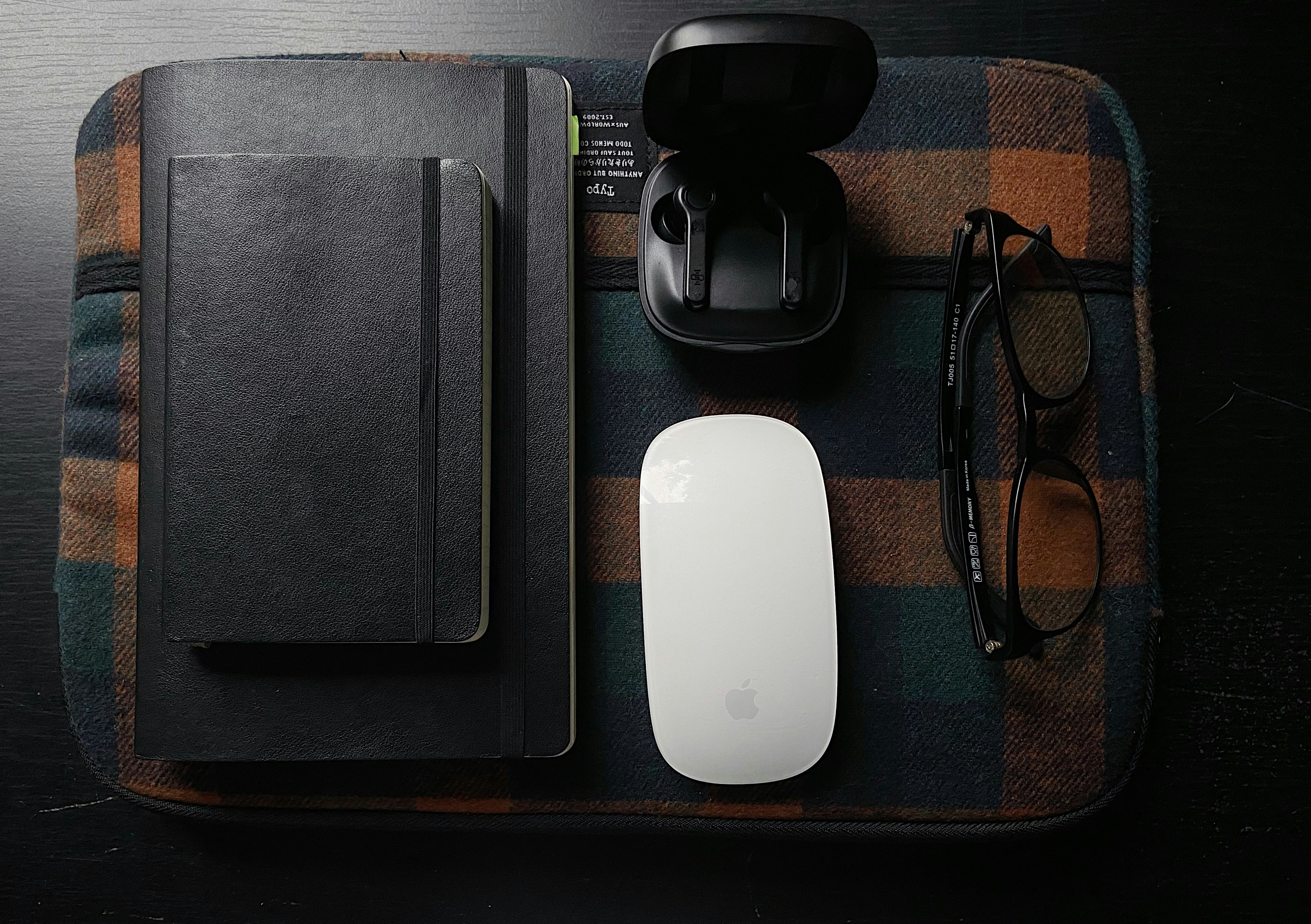 a computer mouse, book, and glasses on a table