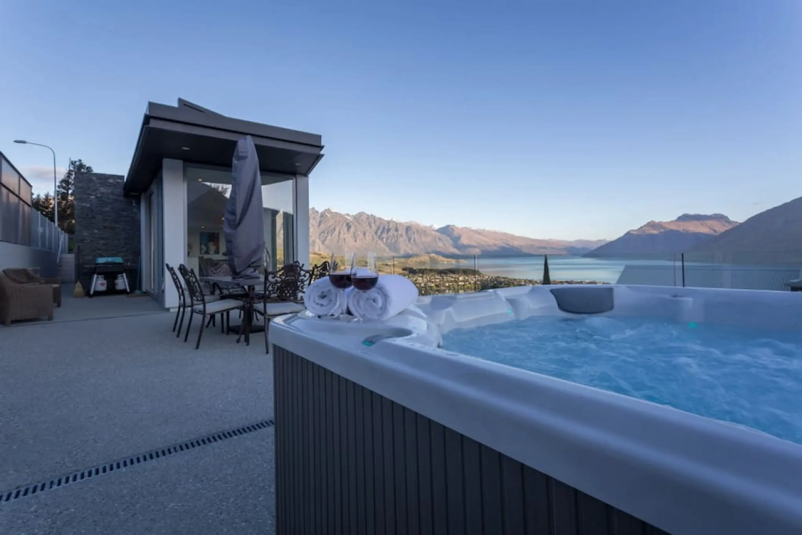 hot tub in queenstown in front of house and lake