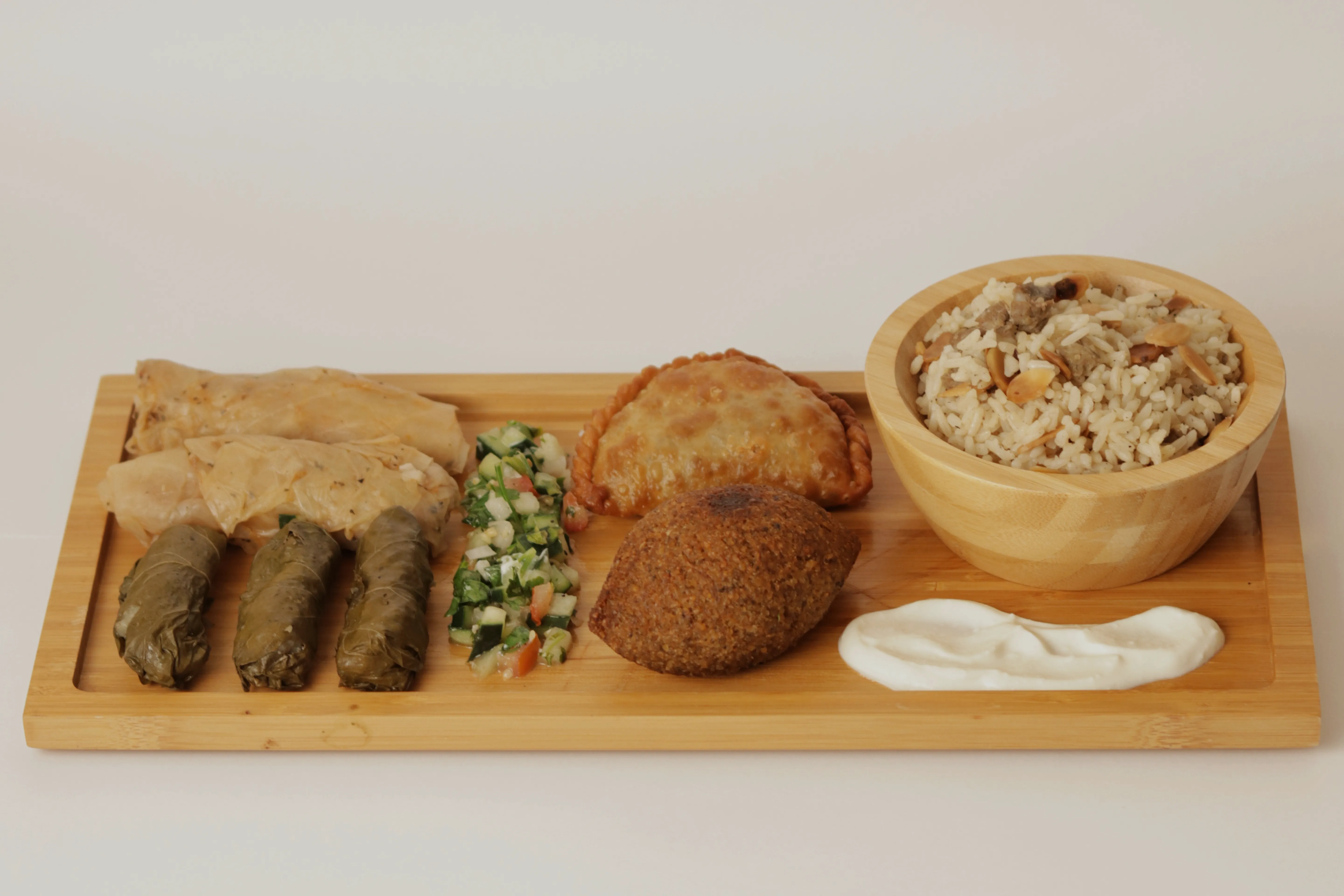 Tabla de degustación con kibbeh, arroz y hojas de parra.